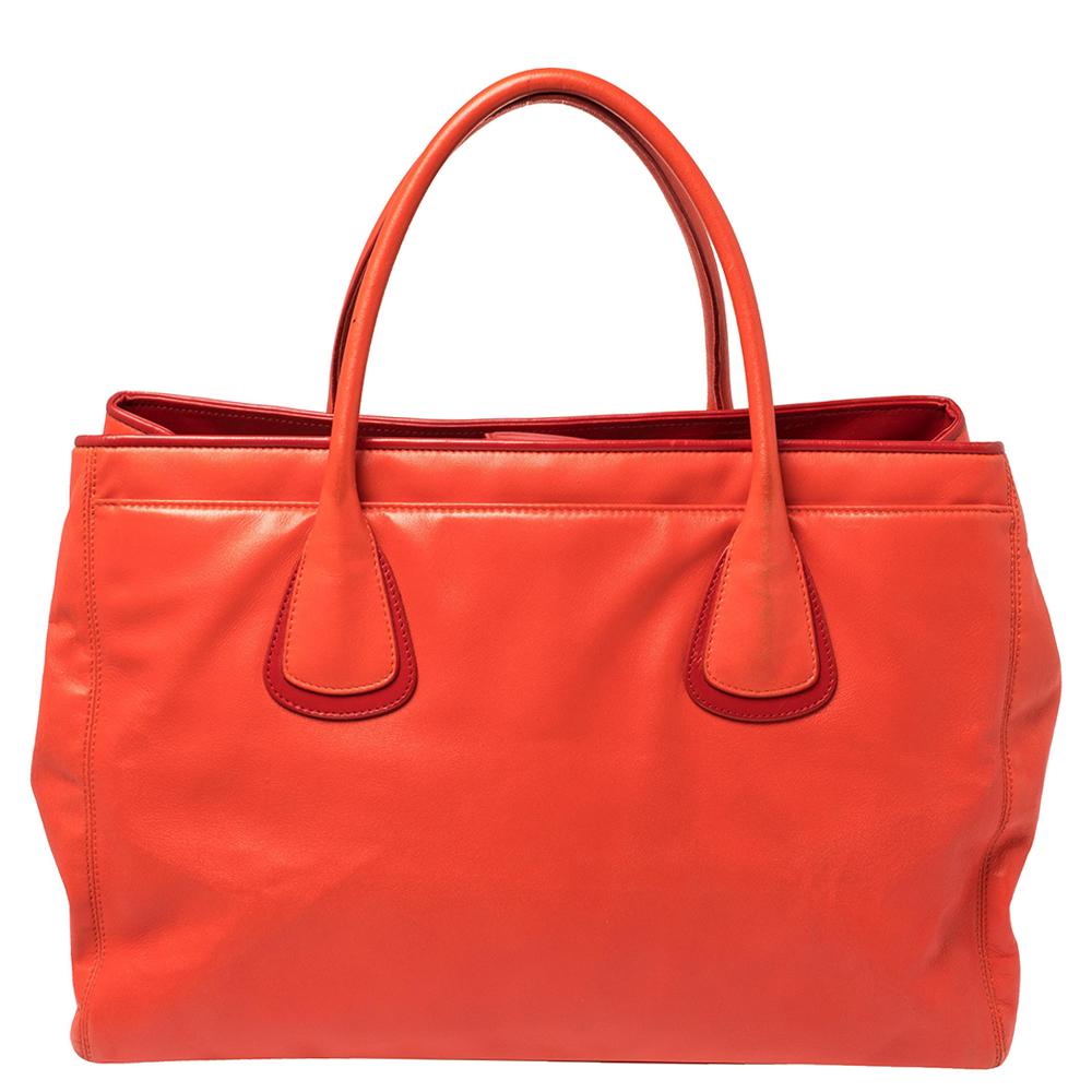 This Cerf tote from Chanel is a perfect blend of practicality and style. It features a red leather construction that is enhanced with a silver-tone CC logo on the front and dual top handles. It is equipped with a spacious fabric-lined interior that