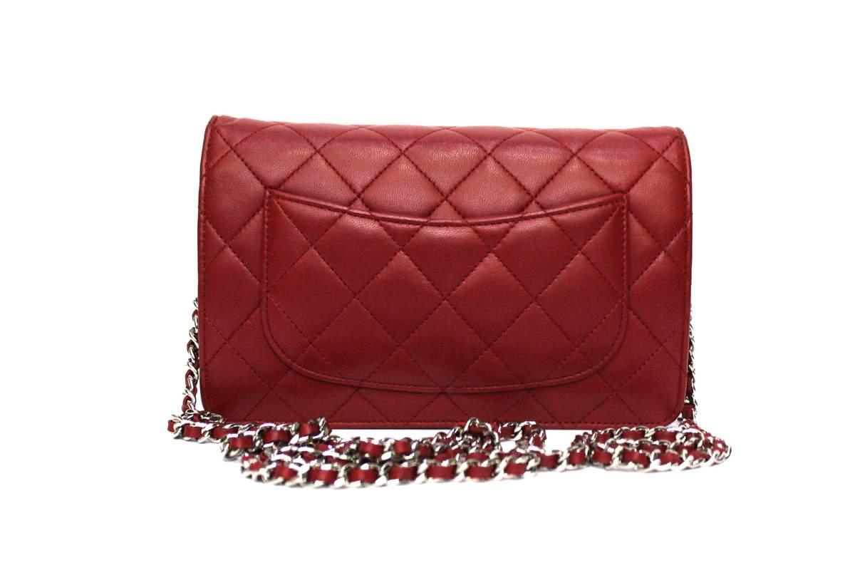 Superb Woc (Wallet with chain) by Chanel made of red quilted lambskin with silver hardware. Decorated on the front by a small CC logo. The versatile leather strap chain can be worn over the shoulder, on the shoulder, doubled to wear it with a