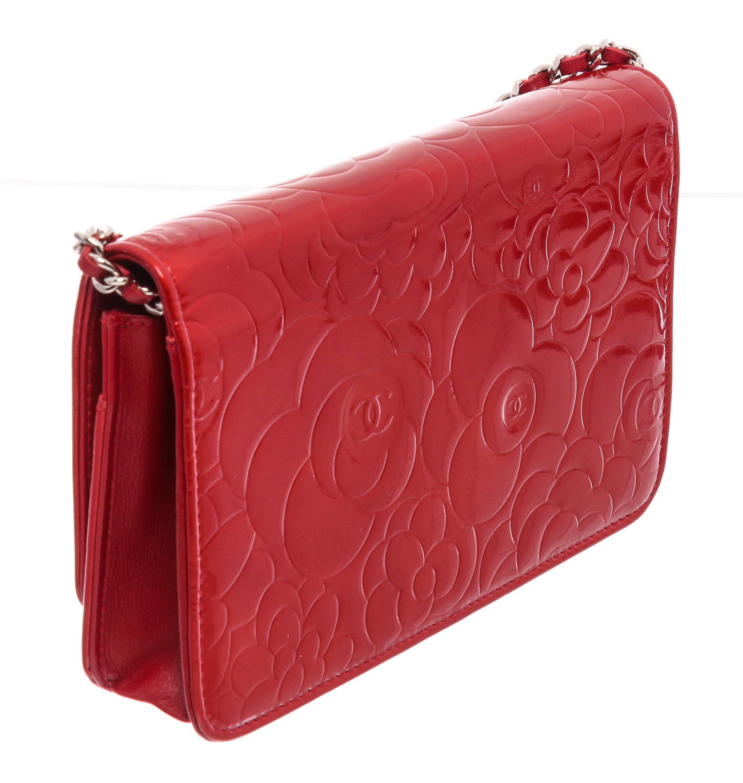 Red Camellia embossed patent leather Chanel Wallet On Chain with silver-tone hardware, single chain-link and leather shoulder strap, CC logo adornment at front, single zip pocket at flap underside, single slit pocket under front flap, tonal satin