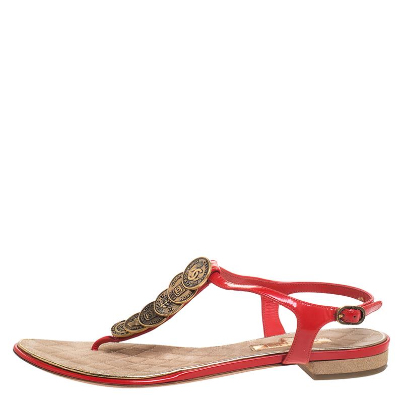 How pretty are these flat sandals from the house of Chanel! They are designed to deliver comfort and style and are crafted in Italy. They are made with patent leather straps in a thong design with buckled ankle fastenings. The uppers feature CC coin