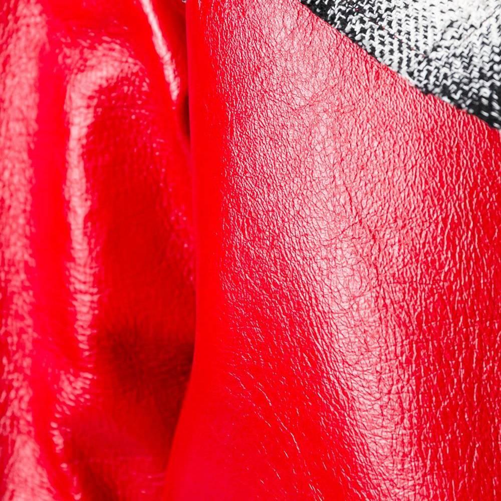 Mit dem scharlachroten Ledermantel von Chanel werten Sie selbst das dezenteste Outfit auf. Dieser Mantel, der auf dem Laufsteg der grafischen Frühjahr/Sommer-Kollektion 2013 präsentiert wurde, hat eine kastenförmige Silhouette in glänzendem Rot und