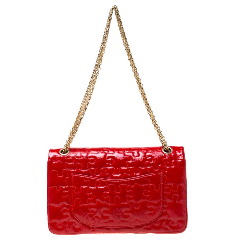 Chanel's Flap bags are iconic and noteworthy in the history of fashion. This Reissue 2.55 is a buy that is worth every bit of your splurge. Exquisitely crafted from red patent leather, it bears a puzzle pattern and the iconic Mademoiselle lock on