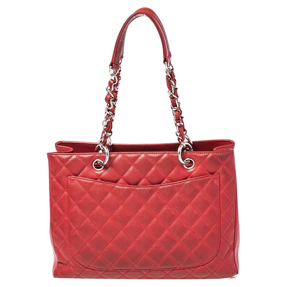 Featuring top handles with chain trim and the CC logo on a quilted pattern, this Chanel red Caviar leather tote exudes just the right amount of sophistication. The bag features an open-top, with a spacious compartment divided by a zipper. It has an