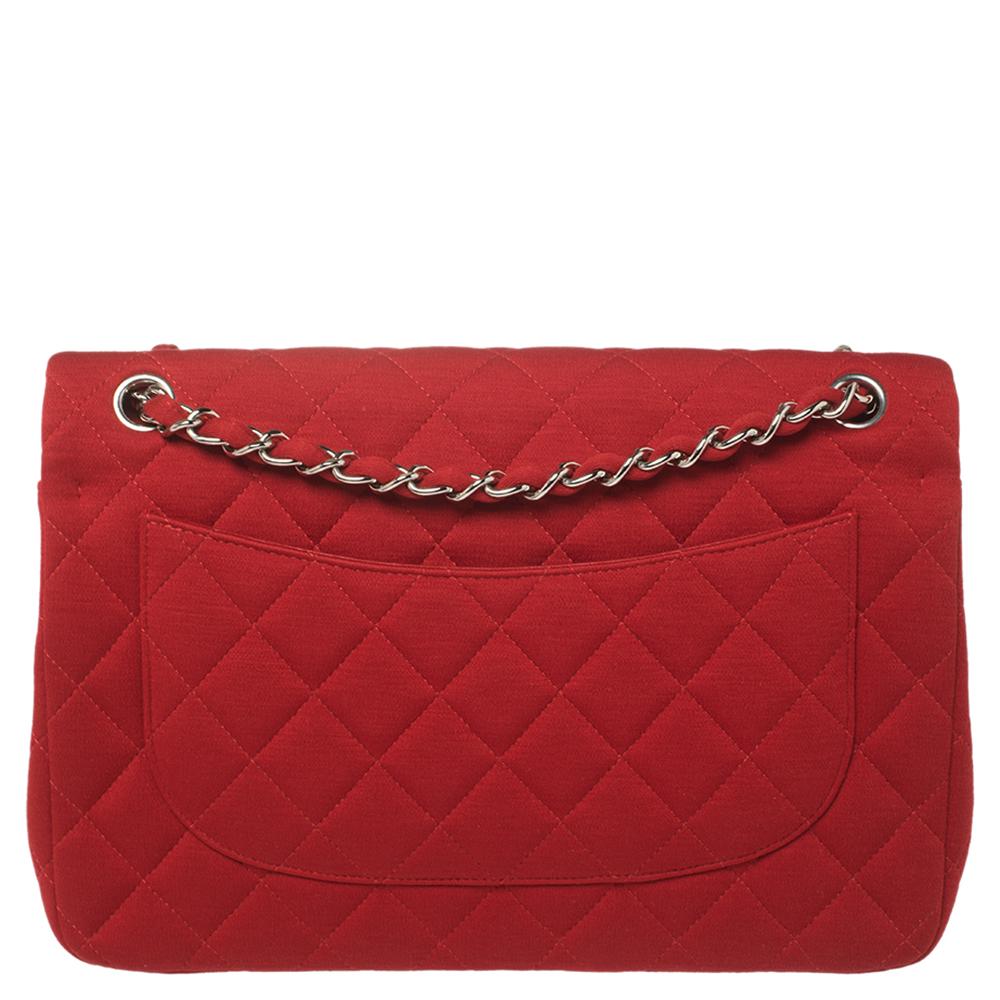 Chanel's Flap bags are the most iconic handbags. The classic double flap bag is crafted from red jersey and features a striking quilted exterior. It has an interwoven strap along with the CC twist lock closure in silver-tone. The flap opens to a