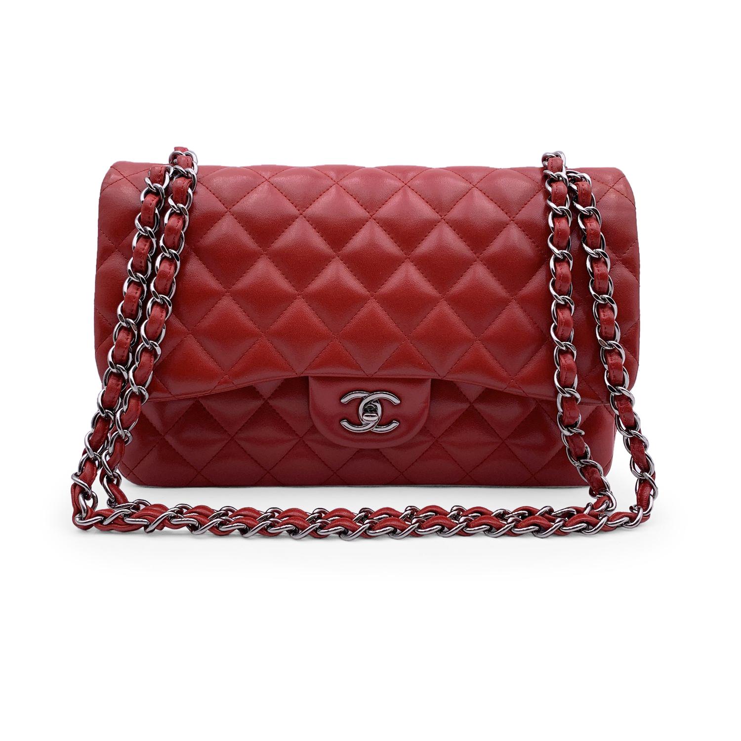 Chanel 'Timeless Classic - Jumbo'. Quilted Double Flap Bag in Red color. Periord/Era: 2014-2015. Features double 'CC' turn lock closure and double flap interior. 1 open pocket under the flap. Gorgeous silver metal strap with interwoven leather; can