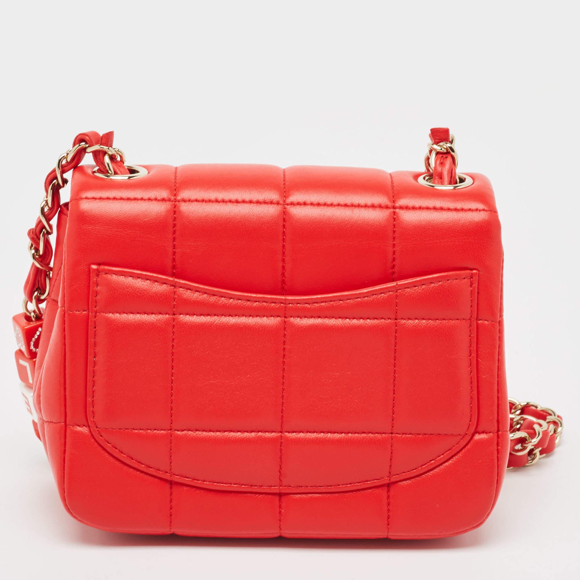 Crafted from luxurious red quilted leather, the Chanel Monacoco flap bag exudes timeless elegance. Its compact design features the iconic CC turn-lock closure and a delicate chain strap with brand details, offering both style and functionality.