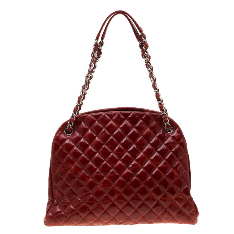 Spacious and captivating, this Just Mademoiselle Bowling bag is from Chanel. It has been crafted from red patent leather and features the iconic quilted pattern. It is equipped with two chain handles and a well-sized fabric interior to keep your