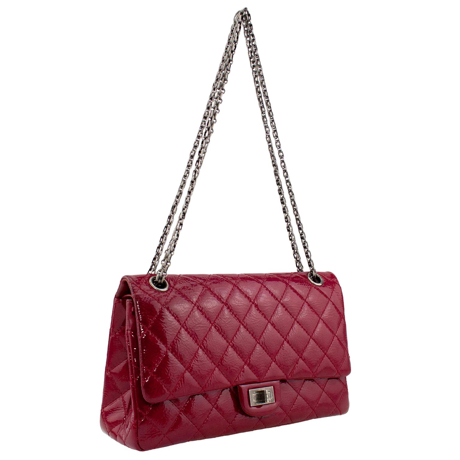 Gorgeous Chanel 2.55 reissue classic flap bag. Quilted raspberry red patent leather with ruthenium Chanel reissue chain shoulder strap and mademoiselle turnlock closure. Chain strap is versatile and can be worn doubled as top handles or long on the