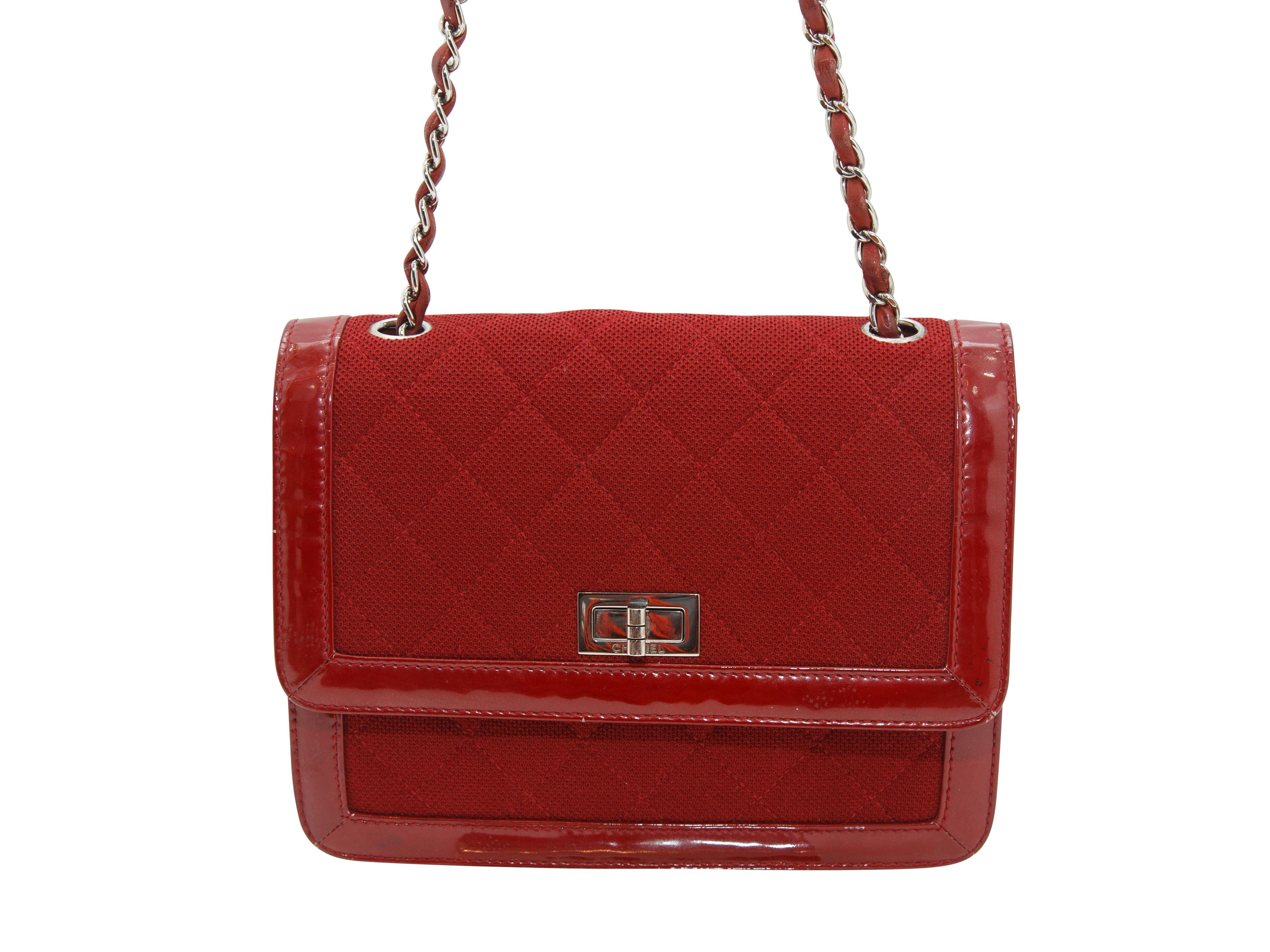 Product details: Red Reissue cloth and patent-trimmed bag by Chanel. Silver-tone hardware. Chain-link strap. Turn-lock closure at front. 9