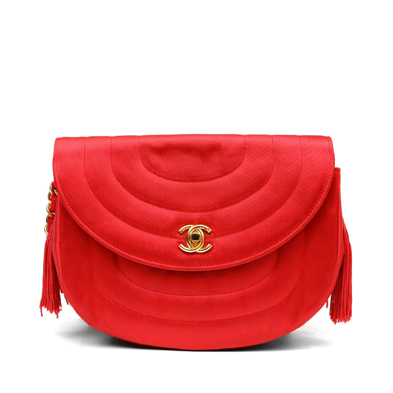 This authentic Chanel Red Satin Vintage Evening Bag is in lovely condition.  Uniquely shaped in vivid red satin, this crossbody piece is truly beautiful.  Bright red satin vintage bag with soft half-moon shaped flap and gold tone hardware accents. 