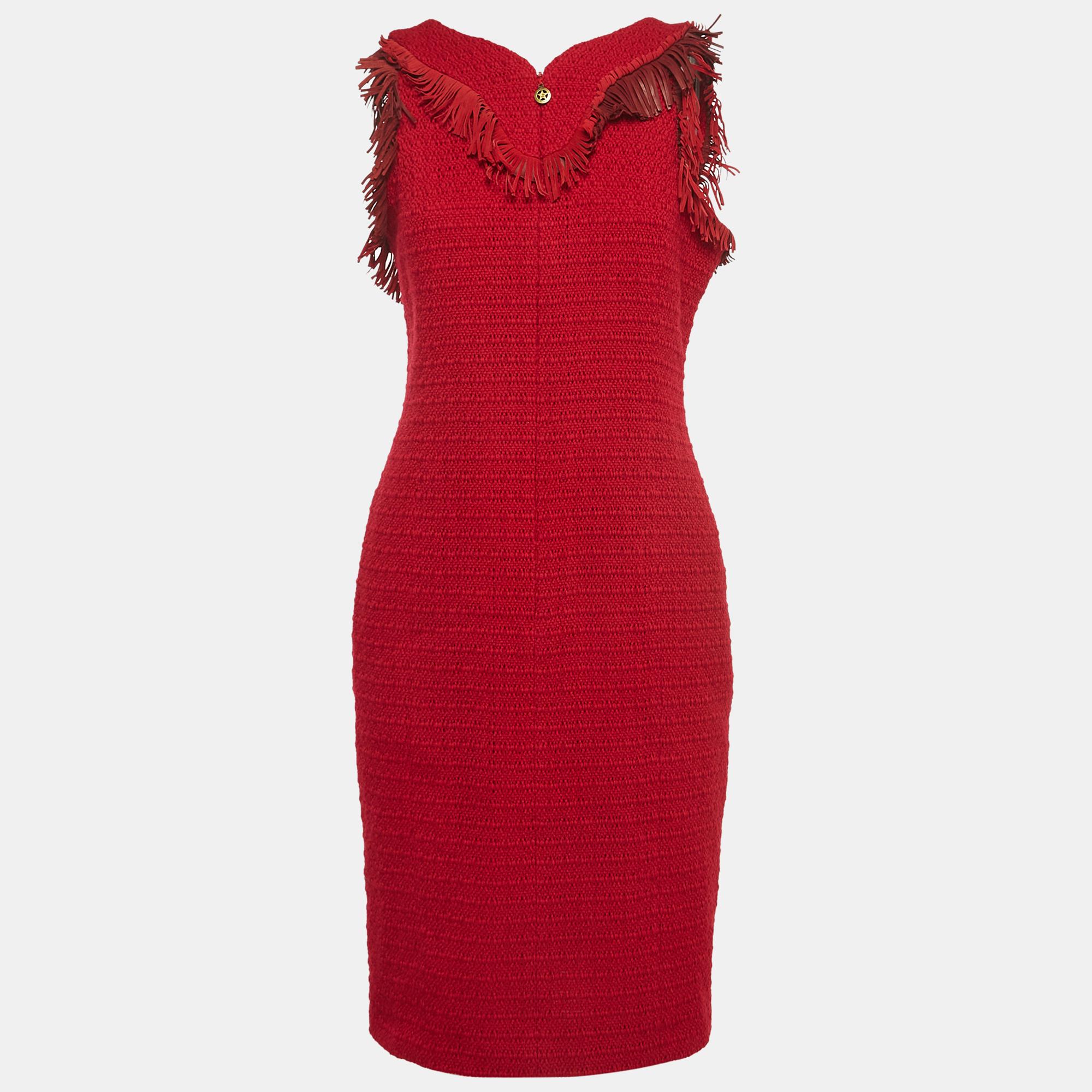 The Chanel dress exudes timeless elegance. The vibrant red hue complements the intricate tweed fabric, while suede fringe accents add movement and sophistication. The sleeveless design and short length create a chic and versatile ensemble for any