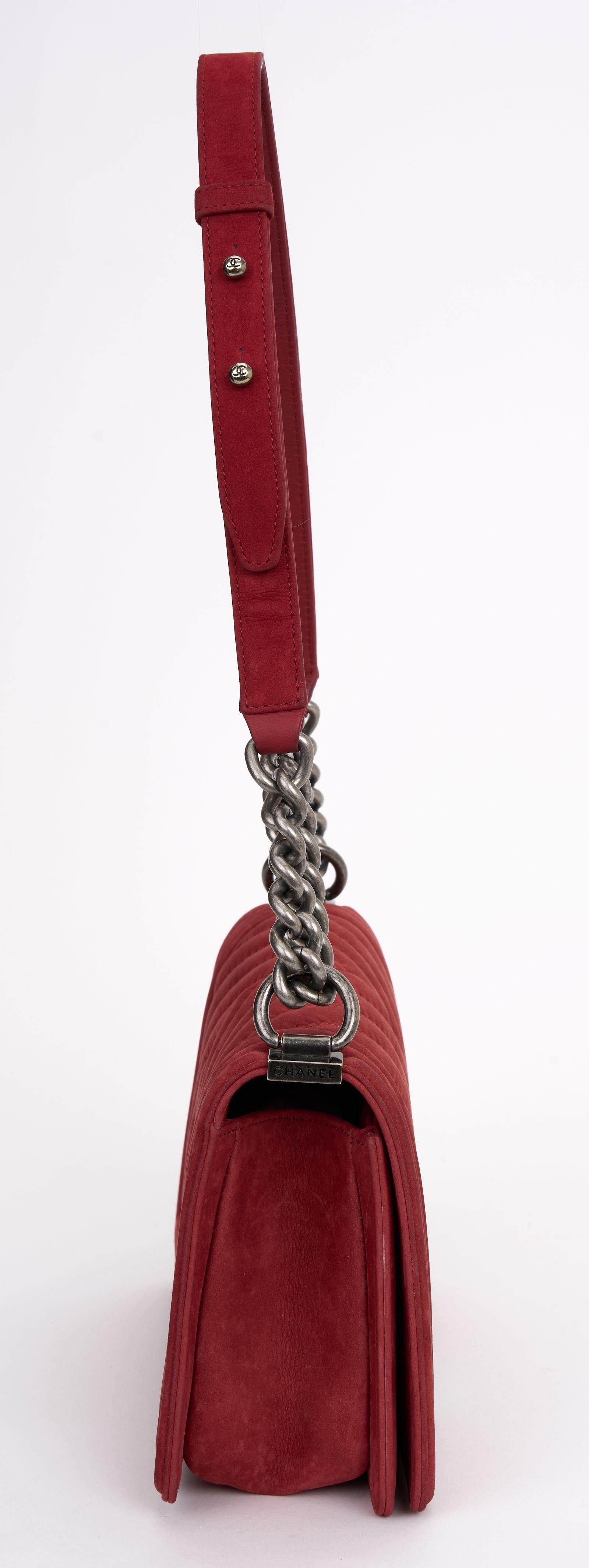 This Chanel Suede Boy Bag features red suede, interlocking CC Logo, antiqued silver-tone hardware, chain link handles and shoulder strap, and a push lock closure at the front. Comes with dust cover. Hologram first two numbers are 23.
Strap drop - 