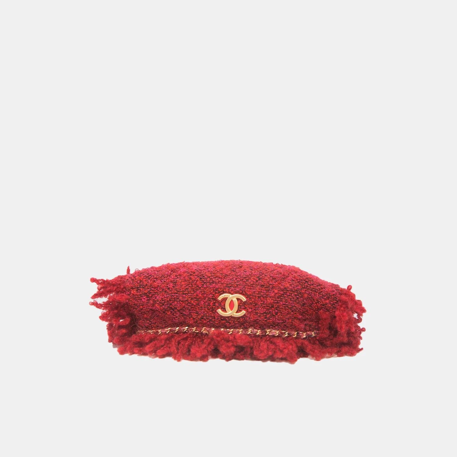 The Chanel Red Tweed Fringed Clutch Bag with Gold Hardware is a stunning piece from the 2017 - 2018 collection. This clutch exudes cosmopolitan class with its fiery red hue and elegant fringe detailing. The interlocking CC medallion and satin lining