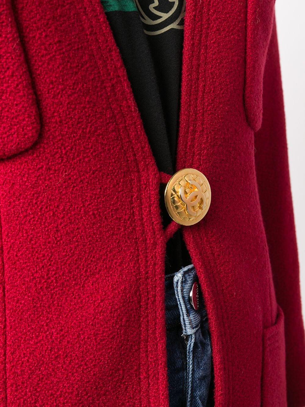 Expertly cut and crafted in France from a striking red wool-blend and a delightful silk lining, this pre-owned, long-sleeved tweed jacket from Chanel showcases the distinct, modern design of wide lapels/ a high standing collar, appliqué detailing