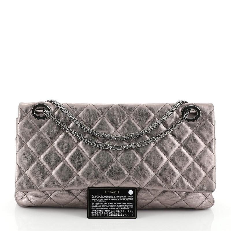 This Chanel Reissue 2.55 Flap Bag Quilted Metallic Aged Calfskin 228, crafted from silver quilted metallic aged calfskin leather, features reissue chain link strap, exterior back slip pocket, and gunmetal-tone hardware. Its mademoiselle turn-lock