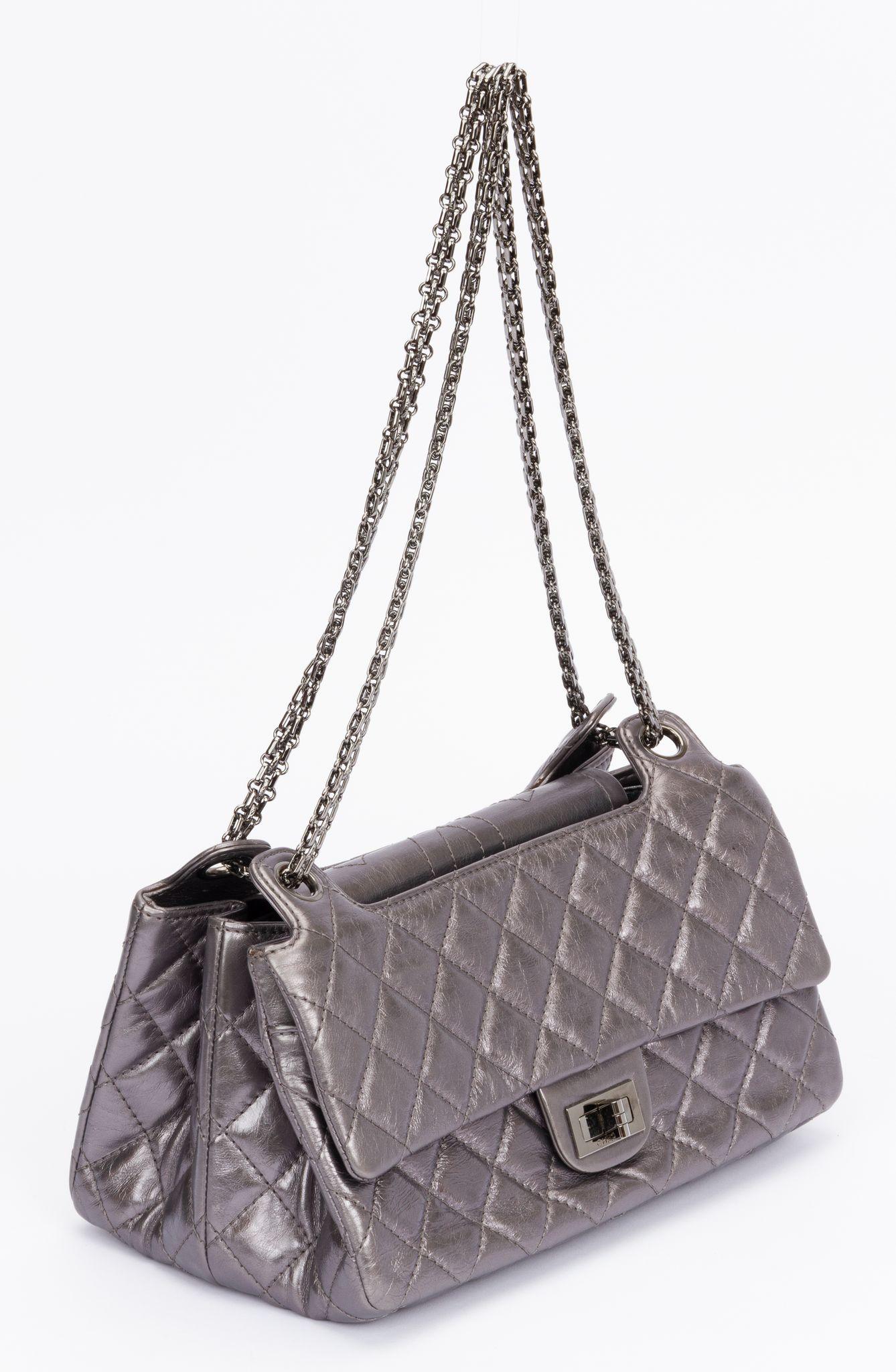 Chanel Reissue Medium Flap bag. The shoulder bag is crafted of quilted calfskin leather in a silver metallic tone. The clasp for closing the back is made of silver hardware and ti be twisted to lock the bag. The chain (11