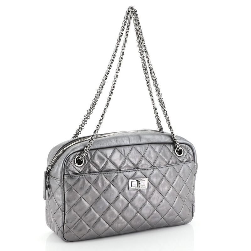 This Chanel Reissue Camera Bag Quilted Aged Calfskin Medium, crafted in metallic silver quilted aged calfskin leather, features iconic silver bijoux chain straps, front pocket with mademoiselle lock closure, exterior back slip pocket and