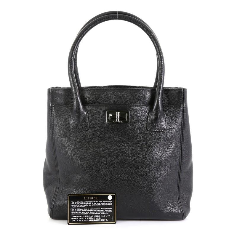This Chanel Reissue Cerf Executive Tote Calfskin Small, crafted in black calfskin leather, features a mademoiselle turn-lock closure, back slip pocket, dual-rolled leather handles, and silver-tone hardware. Its four magnetic snap closures open to a