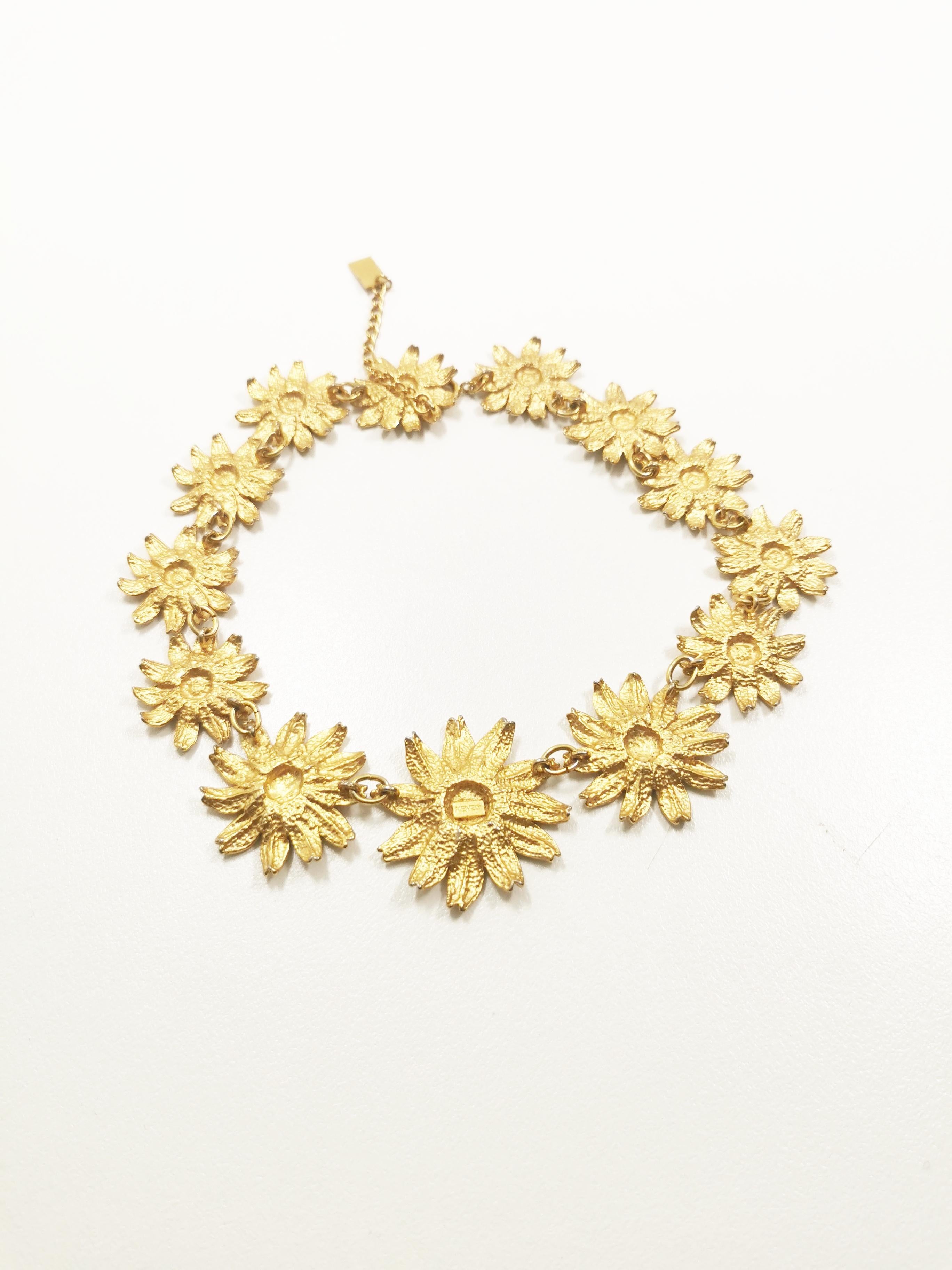 Indulge in the allure of nostalgic glamour with the Vintage KENZO Gerbera Flower Choker, a statement piece that seamlessly marries the romance of yesteryear with the bold elegance of contemporary fashion.

This exquisite choker necklace is a