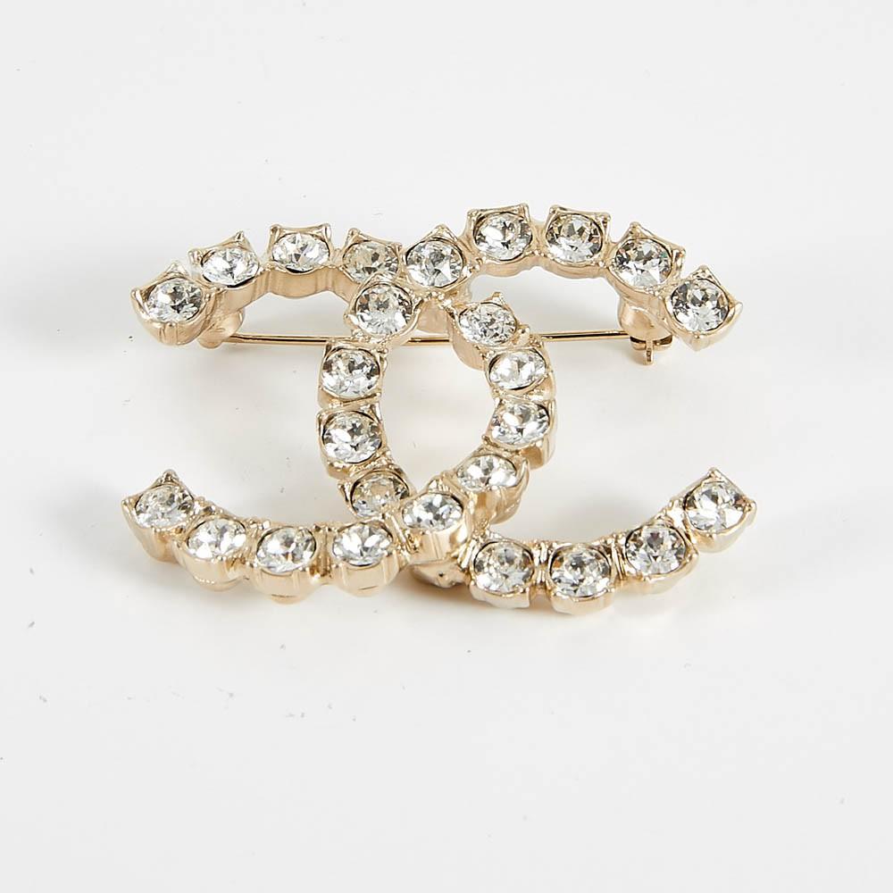 In mint condition, from 2020 summer collection, iconic Chanel interlocking CC logo brooch. With white rhinestone on gold toned metal. Measures : 5 x 3.7 cm.  It will be delivered in a non original dustbag. 