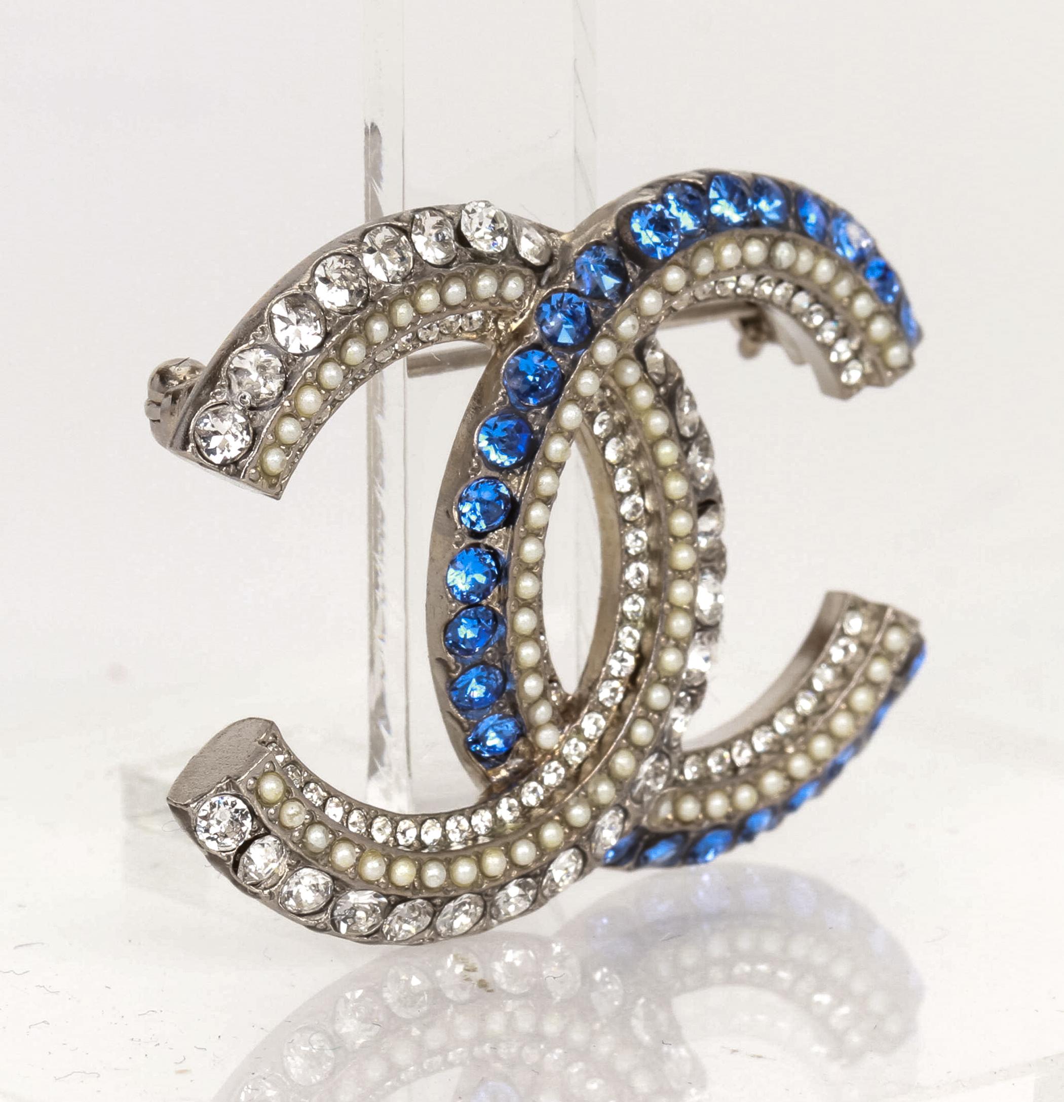 Magnificent Chanel brooch with interlocking CC logo design, with blue and clear rhinestone as well as micro pearls. Comes with velvet pouch.
