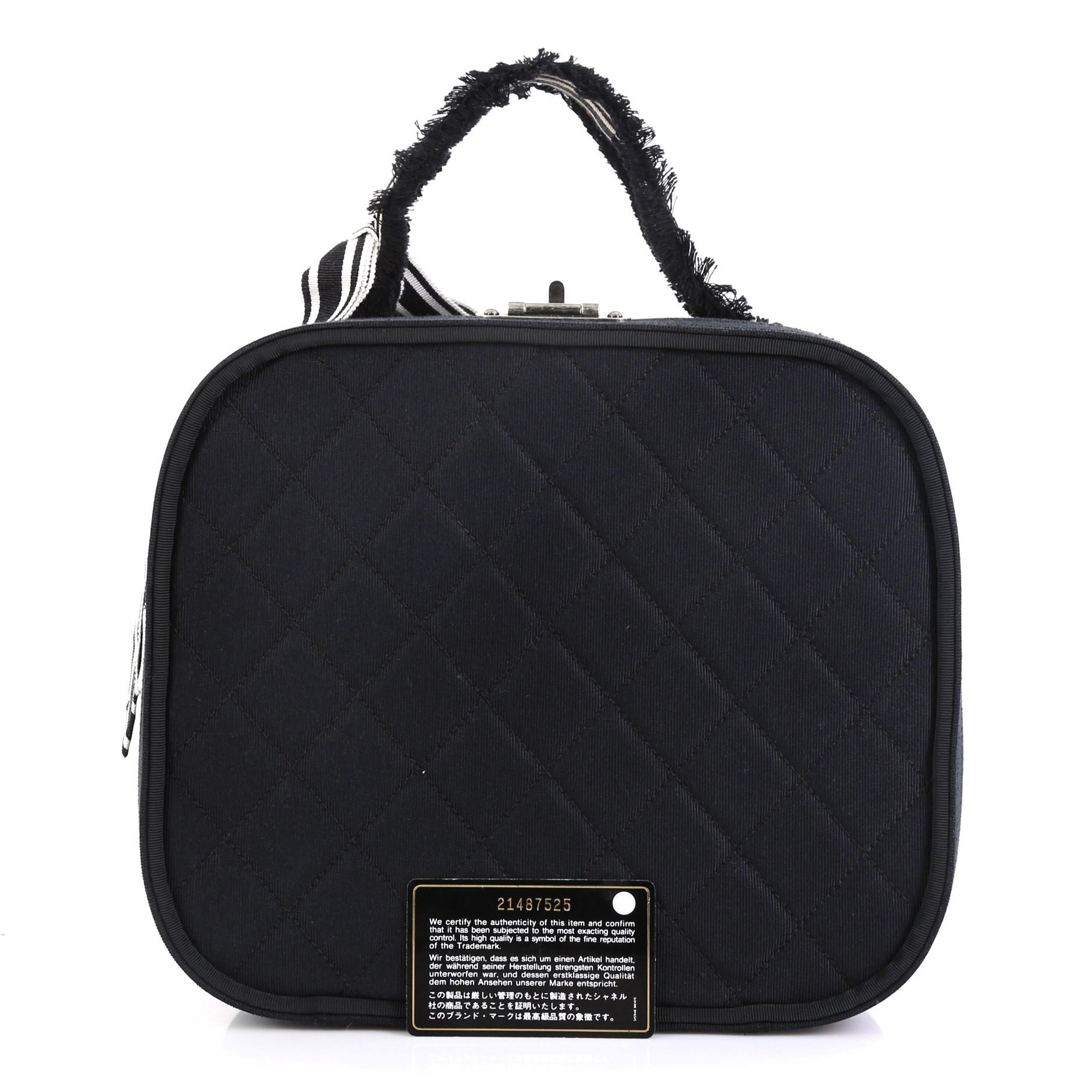 This Chanel Ribbon Vanity Case Quilted Grosgrain Medium, crafted from black quilted grosgrain, features a top handle and aged silver-tone hardware. It opens to a black microfiber interior. Hologram sticker reads: 21487525. 

Condition: Great. Marks