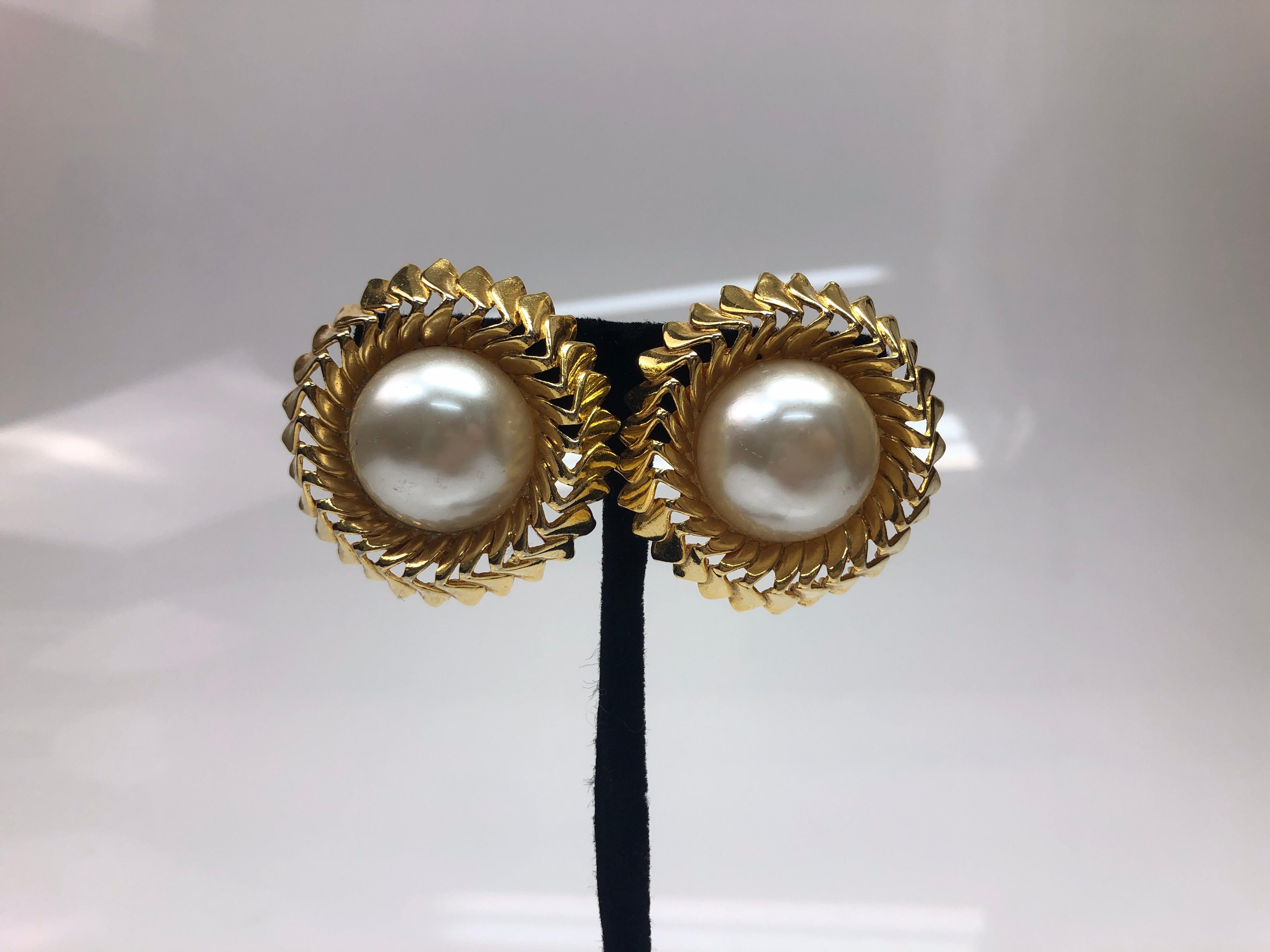 Chanel Rippled Gold Tone w/ Large Pearl Center Earrings. These beautiful Chanel earrings are in excellent condition. They show barely any sign of use. They are clip on earrings, with no back cushion or gel pad. They have a gold ripple design on the