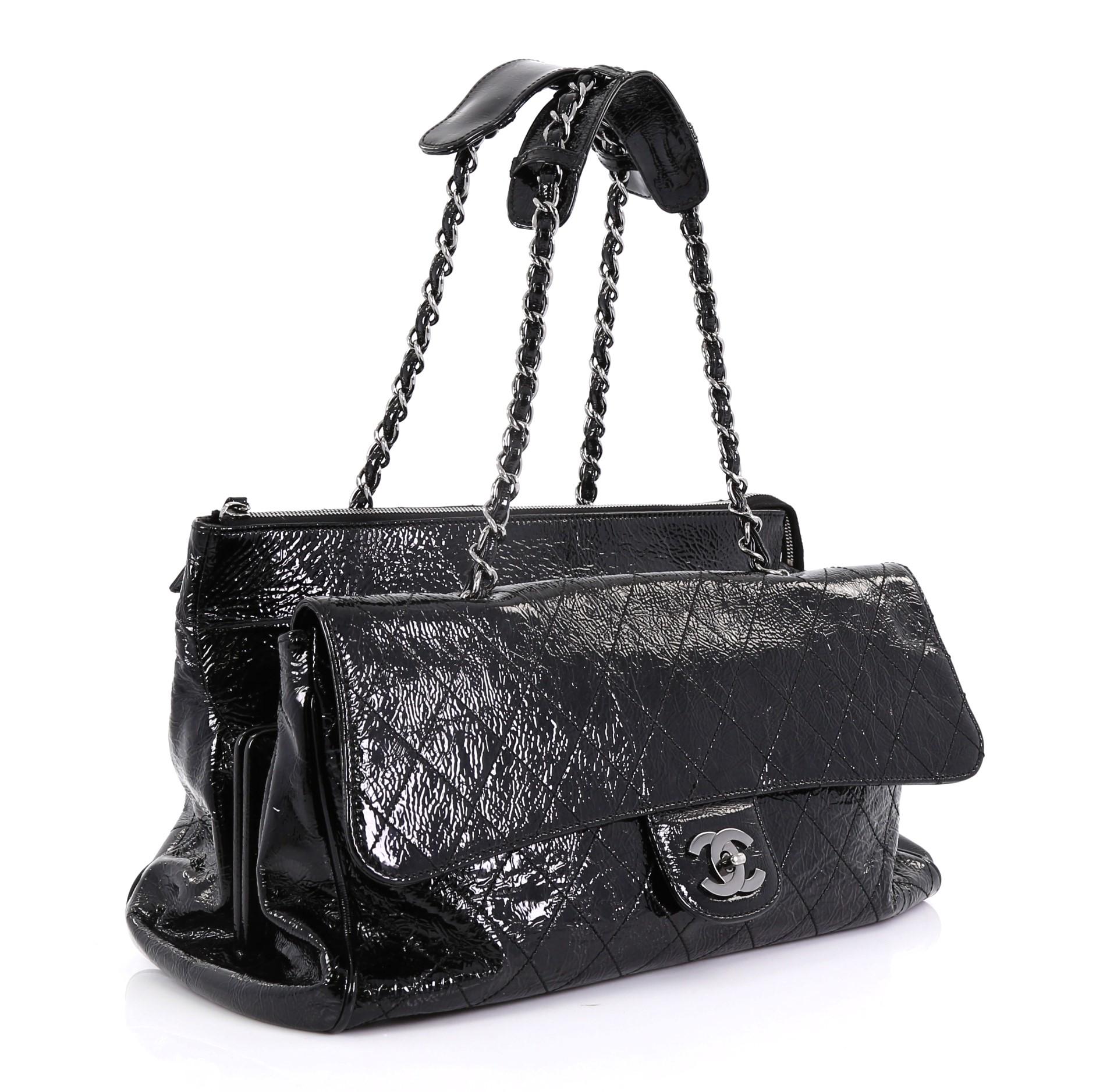 This Chanel Ritz Flap Bag Quilted Patent Large, crafted from black quilted patent leather, features dual woven-in leather chain straps with shoulder pads, exterior flap compartment with CC turn-lock closure, middle framed compartment with push-pin