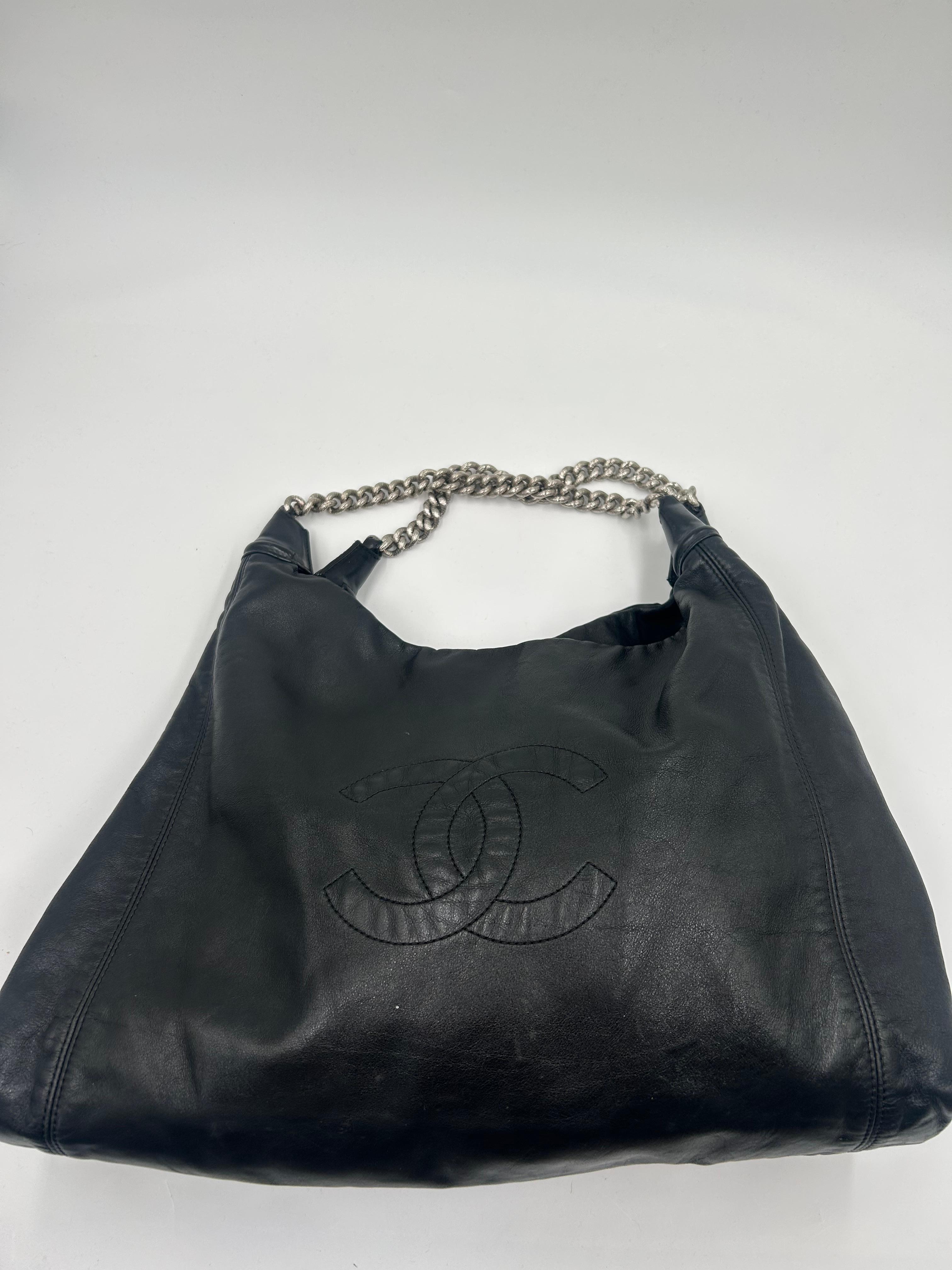 Borsa Hobo Chanel Rodeo Drive in pelle di agnello nera 2008. 
La borsa Hobo Chanel Rodeo Drive in pelle d'agnello nera del 2008-2009 è una versione splendidamente rilassata ma sofisticata dell'artigianato Chanel. Realizzata in morbida pelle