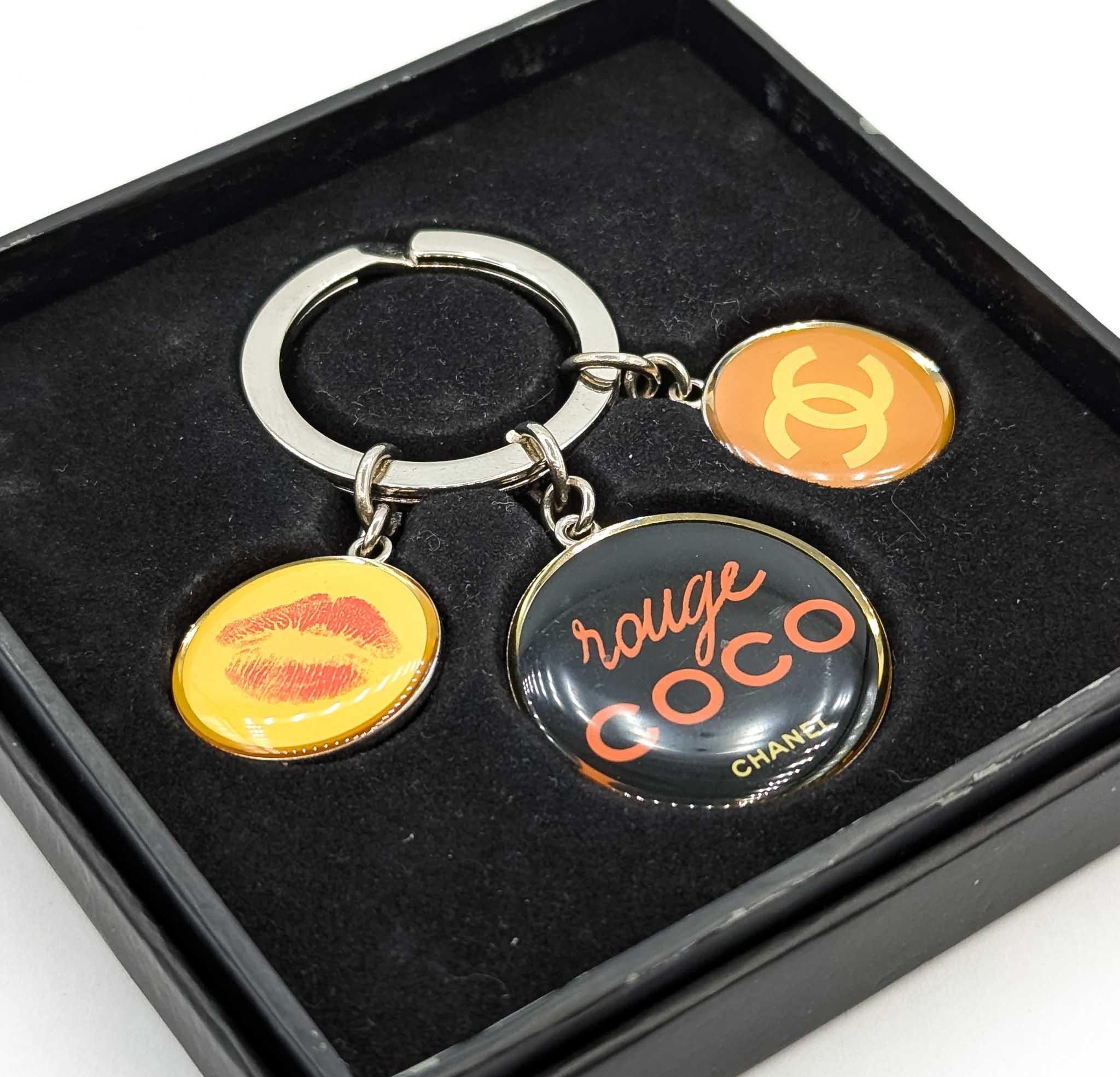 Add a touch of iconic elegance to your daily essentials with this pre-owned Chanel Rouge Coco 2010 Novelty Keyring. This exquisite designer accessory is perfect for fashion enthusiasts who appreciate timeless style and sophistication. Crafted with