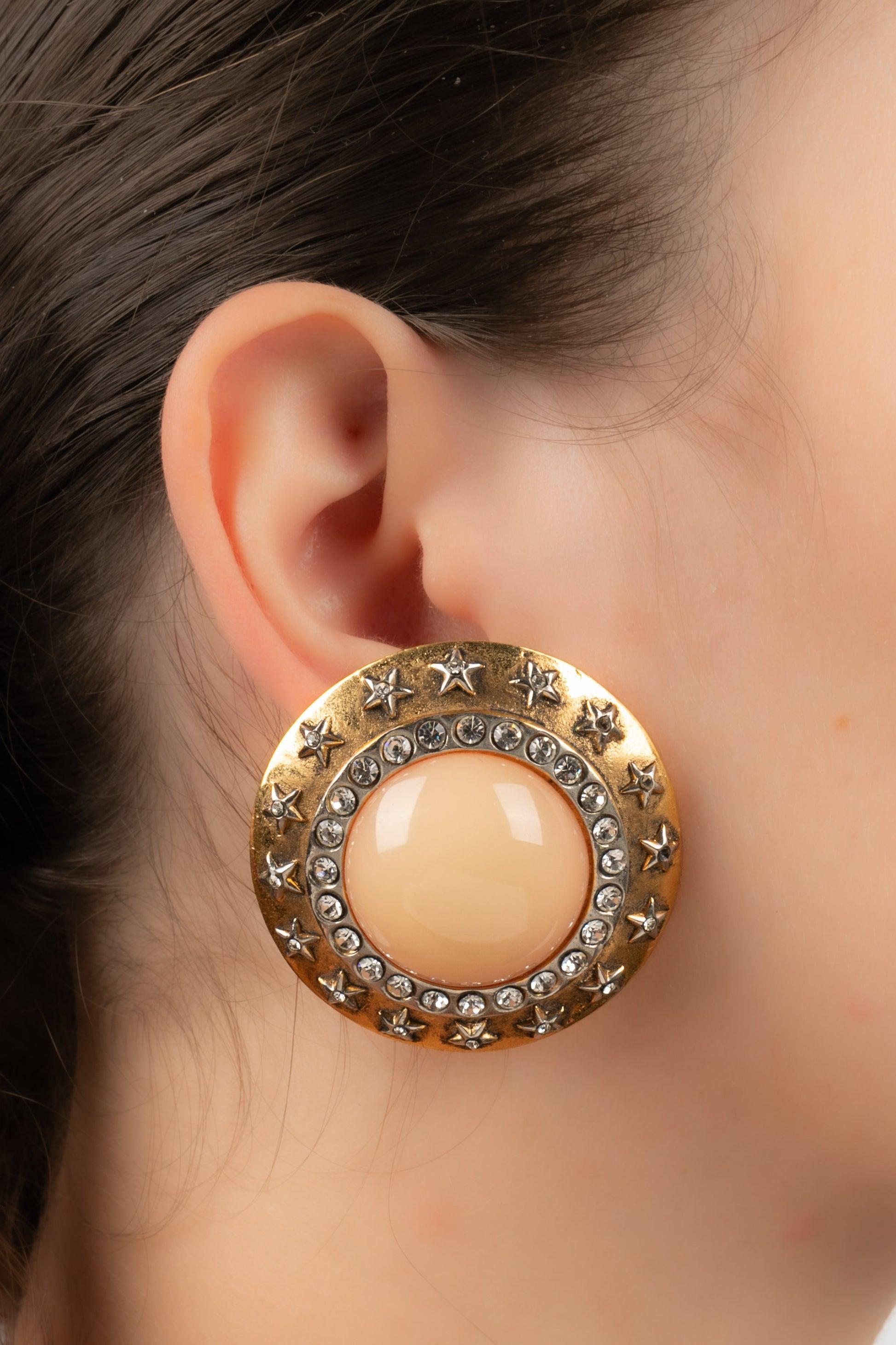 Chanel - Round clip-on earrings in golden metal and rhinestones. Central cabochon in glass paste.

Additional information:
Condition: Very good condition
Dimensions: Diameter: 4 cm

Seller Reference: BOB217
