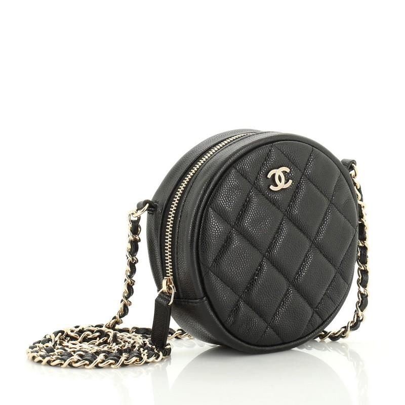 This Chanel Round Clutch with Chain Quilted Caviar Mini, crafted from black quilted caviar leather, features woven-in leather chain strap and gold-tone hardware. Its zip closure opens to a red fabric interior with slip pocket. Hologram sticker