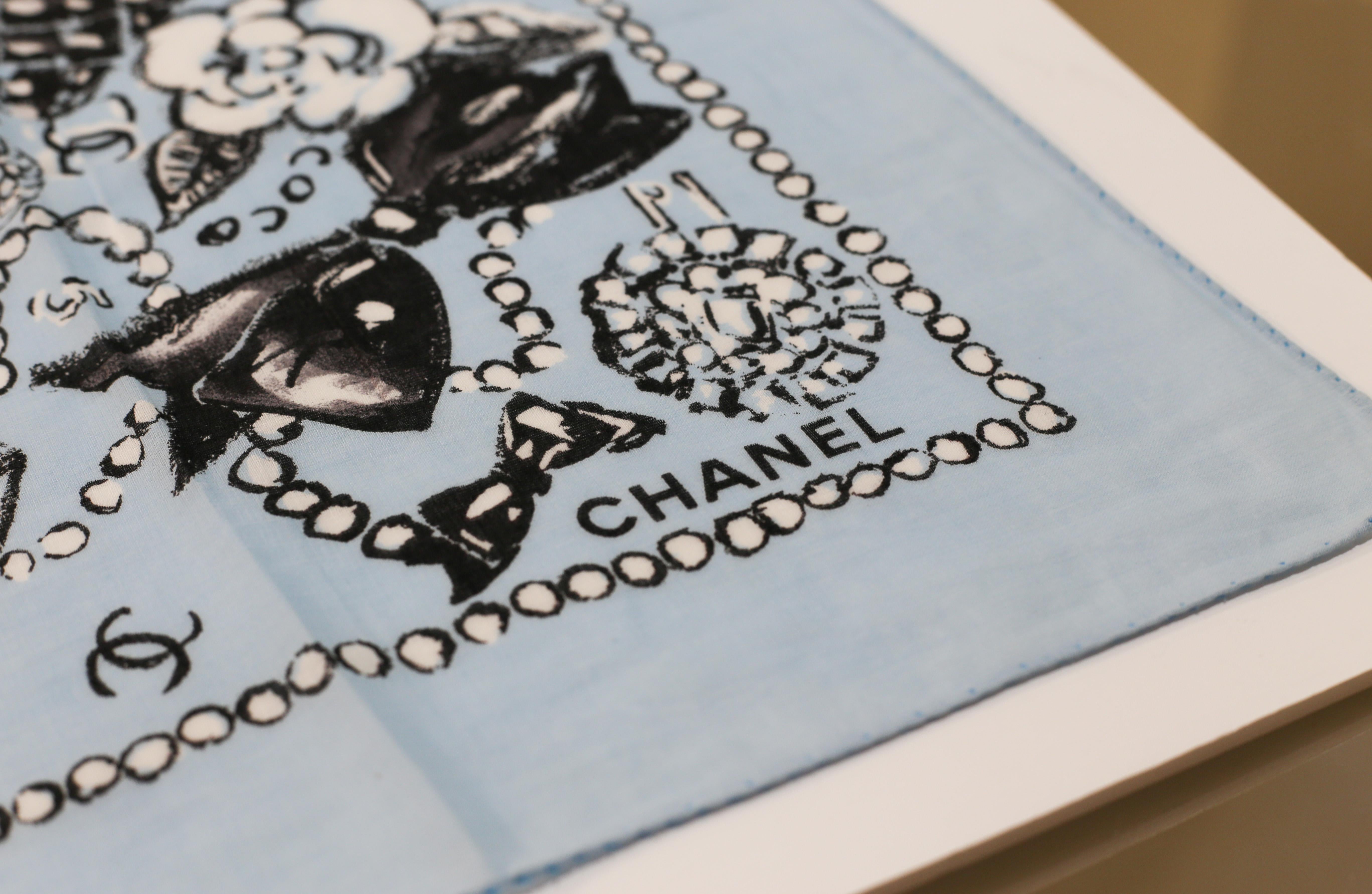 Echarpe paréo CHANEL
Un élégant paréo de plage en coton avec le logo CC de Chanel imprimé en noir et blanc sur une couleur bleu baba. 
Dress to Impress - un accessoire Chanel indispensable dans votre garde-robe:: à porter de différentes manières et