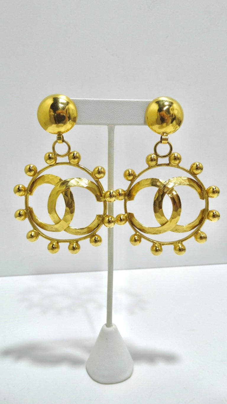 Circa late 80s these stunning Chanel Runway earrings are sure to show stop. These are a statement within themselves as are large in size and include bold detailing. Includes a large 'CC' cutout, interesting metal beading around the perimeter, and a