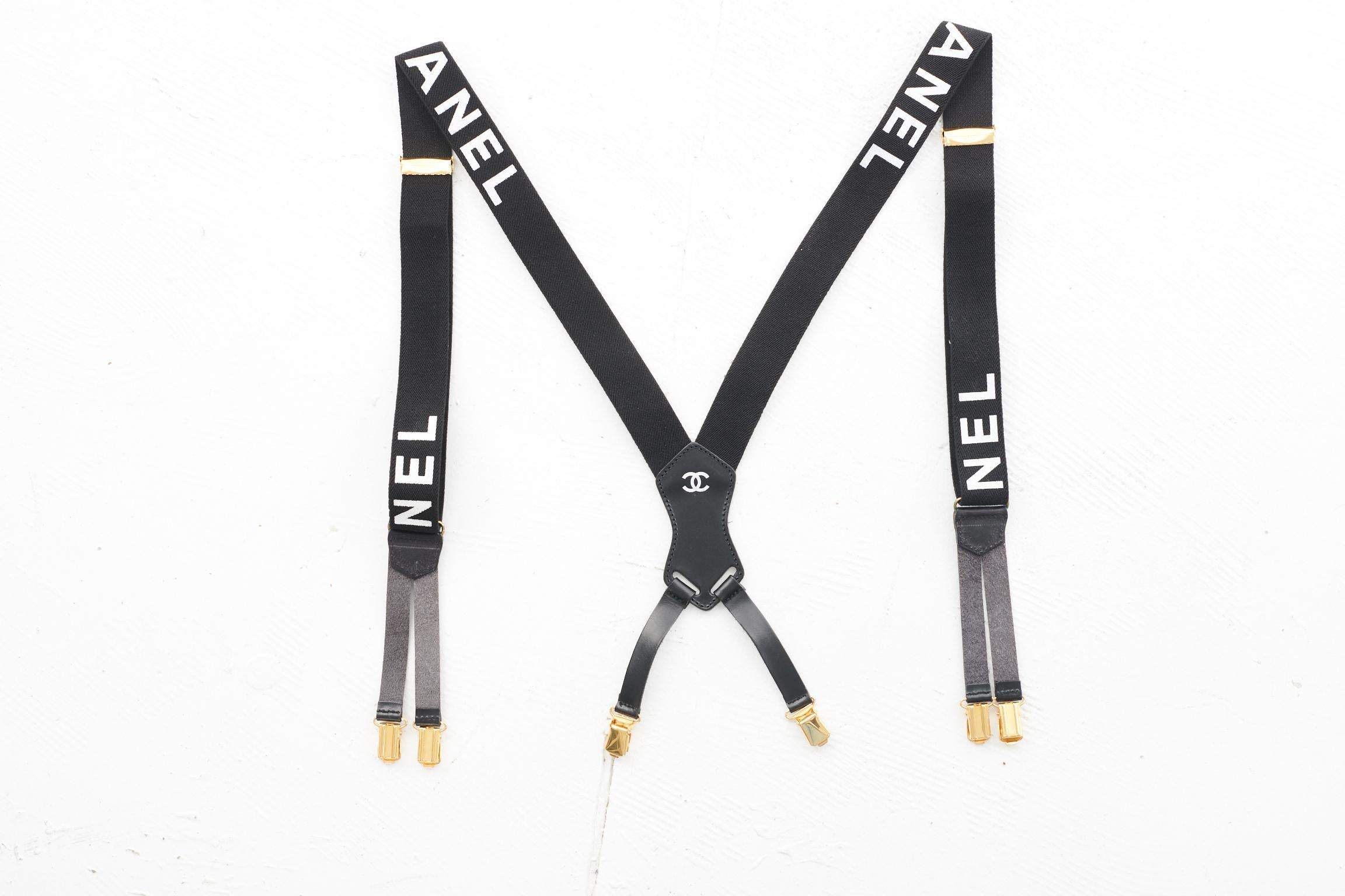 Iconic ! Rare ! Stylish ! From the famous Chanel Spring-Summer 1994 collection and featured in the season's ad campaign, these suspenders feature adjustable black elastic straps with gold tone clips dealings. Tonal leather details. White bold print