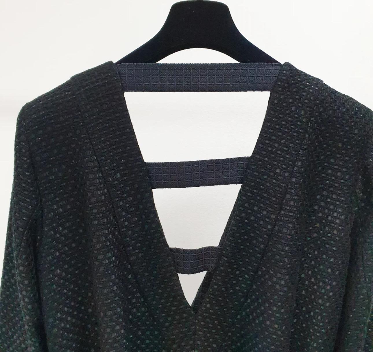 Petite veste noire Chanel avec ceinture de la Collection Cruise Paris / SEOUL, look # 52 du Catwalk. 

Marque de taille 48 fr. 

L'état est excellent. 

- Fabriqué en tweed noir. 
- Boutons du logo CC. 

Le cintre n'est pas inclus.