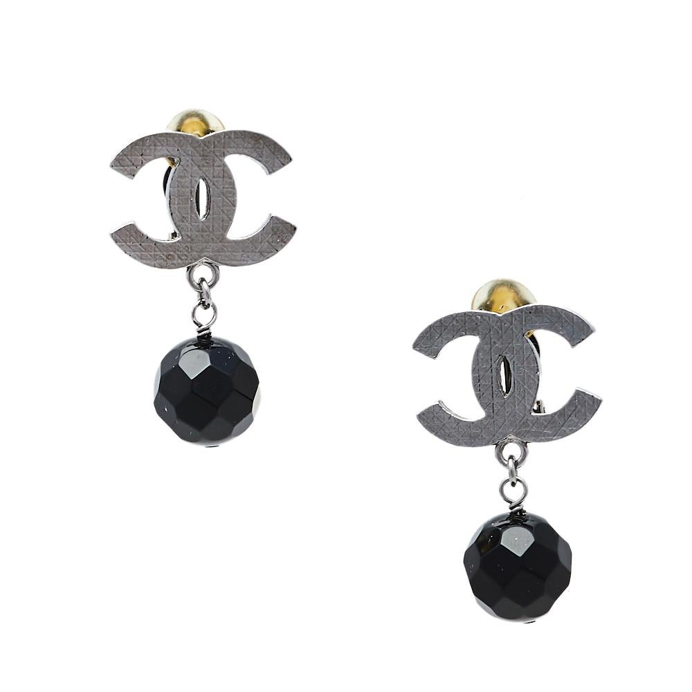 Exhibiting Chanel's rich craftsmanship and timeless design aesthetics, these earrings are meant to be flaunted. Crafted using ruthenium metal, they feature the CC logo and a black bead. The clip-on backs secure the beautiful Chanel CC earrings.

