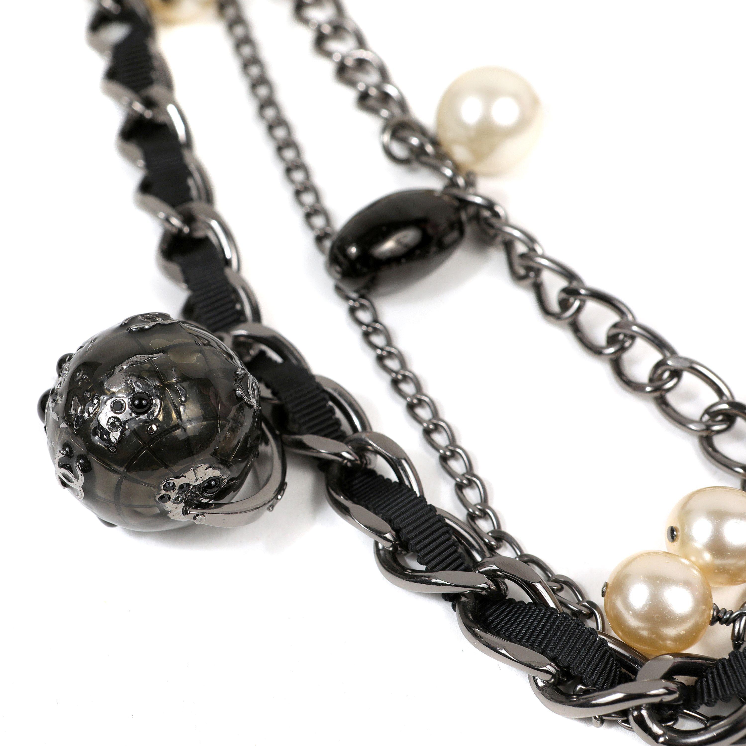 This authentic. Chanel Ruthenium Globe Multi Chain Necklace with Pearls is pristine.  Three strands of different ruthenium chains are anchored together at the clasp.  Dangling globes, faux pearls and ccs enhance the design.  Pouch or box included.