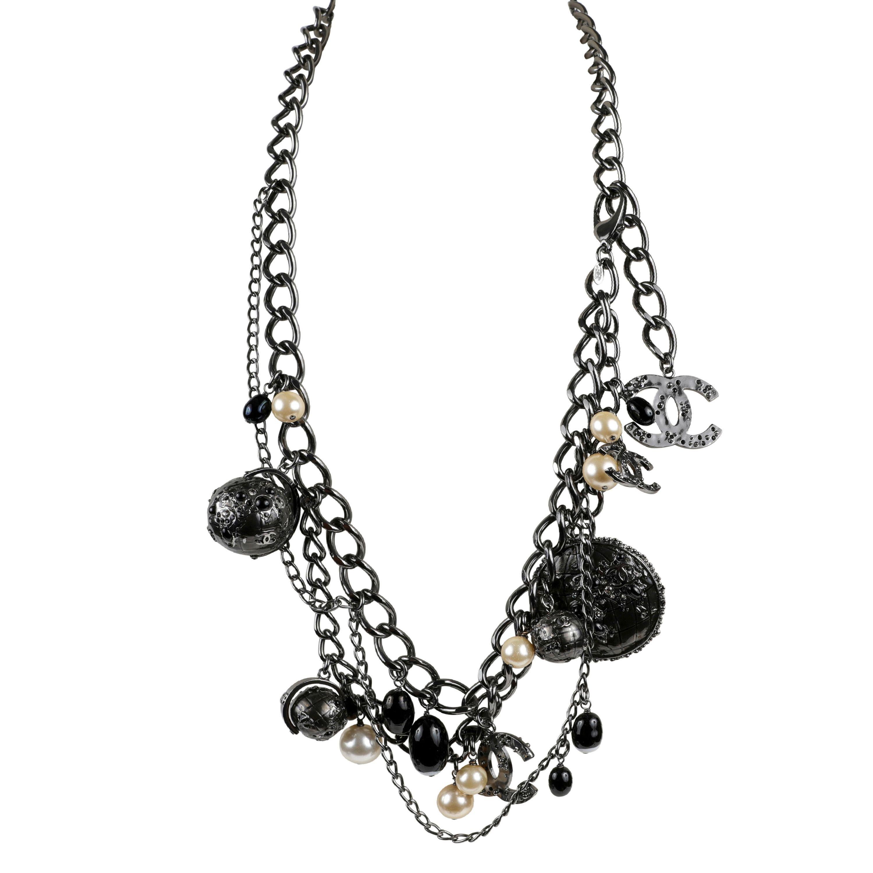 This authentic Chanel Ruthenium Globe Multi Strand Belt with Pearls is in pristine condition.  Ruthenium chains with dangling faux pearls, CC charms, black beads and flower applique globe charms.    May be worn as a belt or a necklace.  Pouch or box