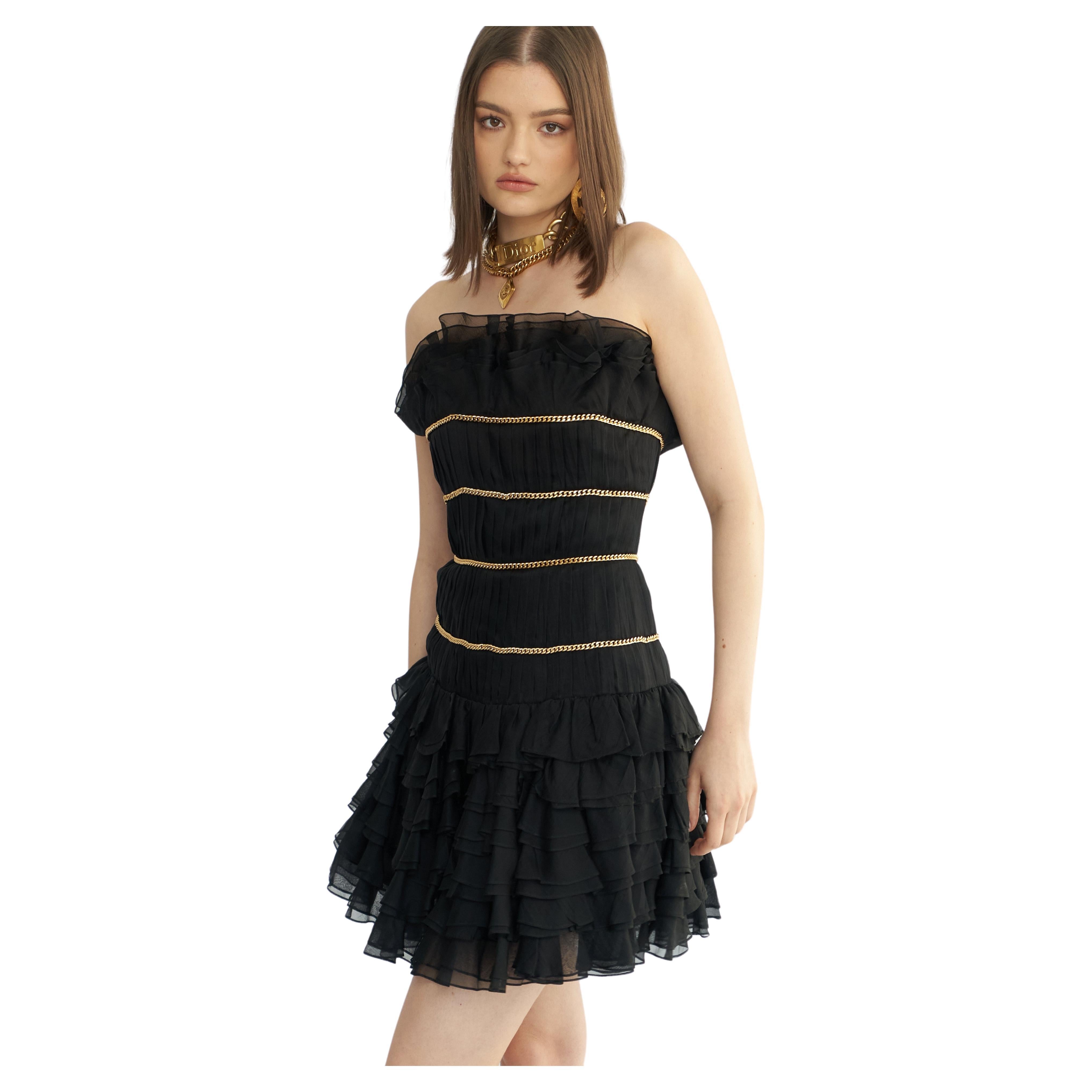 Datant de la Collection S/S 1988, une version plus longue de cette robe est apparue sur le podium de Chanel. Composée de plusieurs couches de mousseline de soie noire, elle présente un décolleté et une jupe sans bretelles à volants, ainsi qu'un