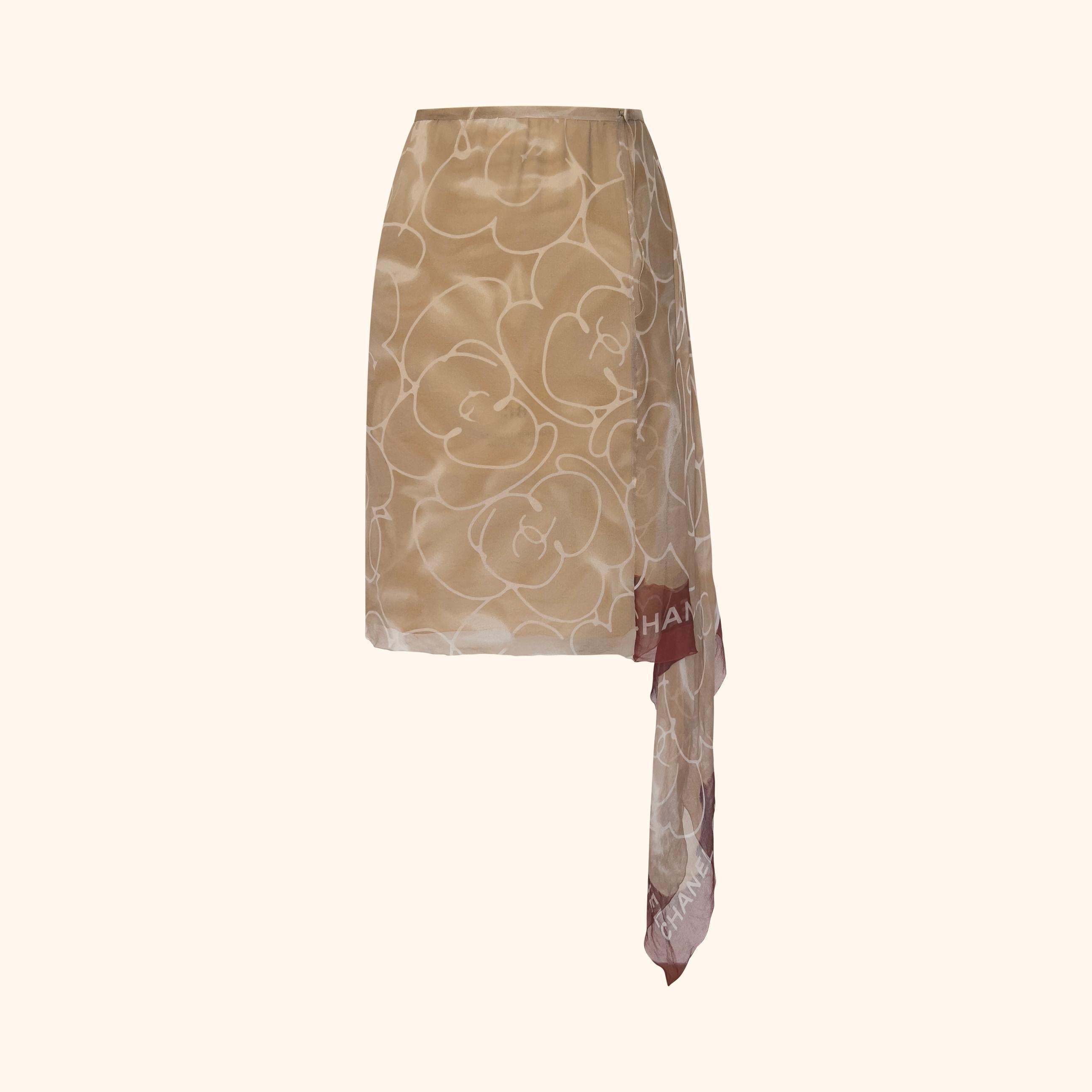 Cette jupe a été vue sur le podium de la collection printemps/été 1999, portée par Aurélie Claudel.
Jupe en soie légère imprimée de motifs de camélias surdimensionnés dans les tons beige et ivoire.
Elle est dotée d'un empiècement asymétrique en