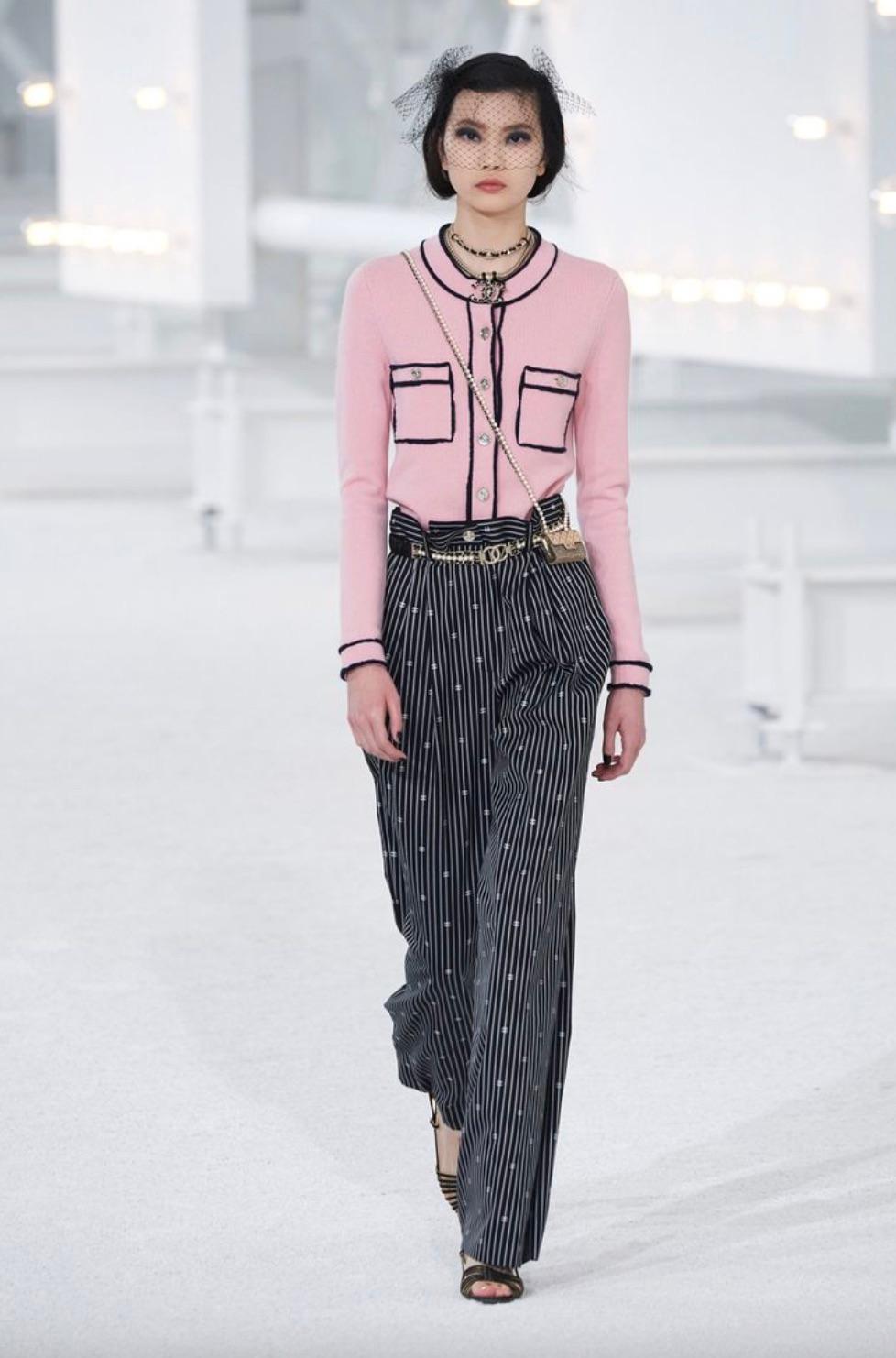 From the Chanel Spring 2021 collection, this iconic pink cashmere cardigan became a favorite among fashion bloggers and celebrities. Its soft pastel hue is beautifully contrasted by midnight blue trim, accentuating the structured silhouette and