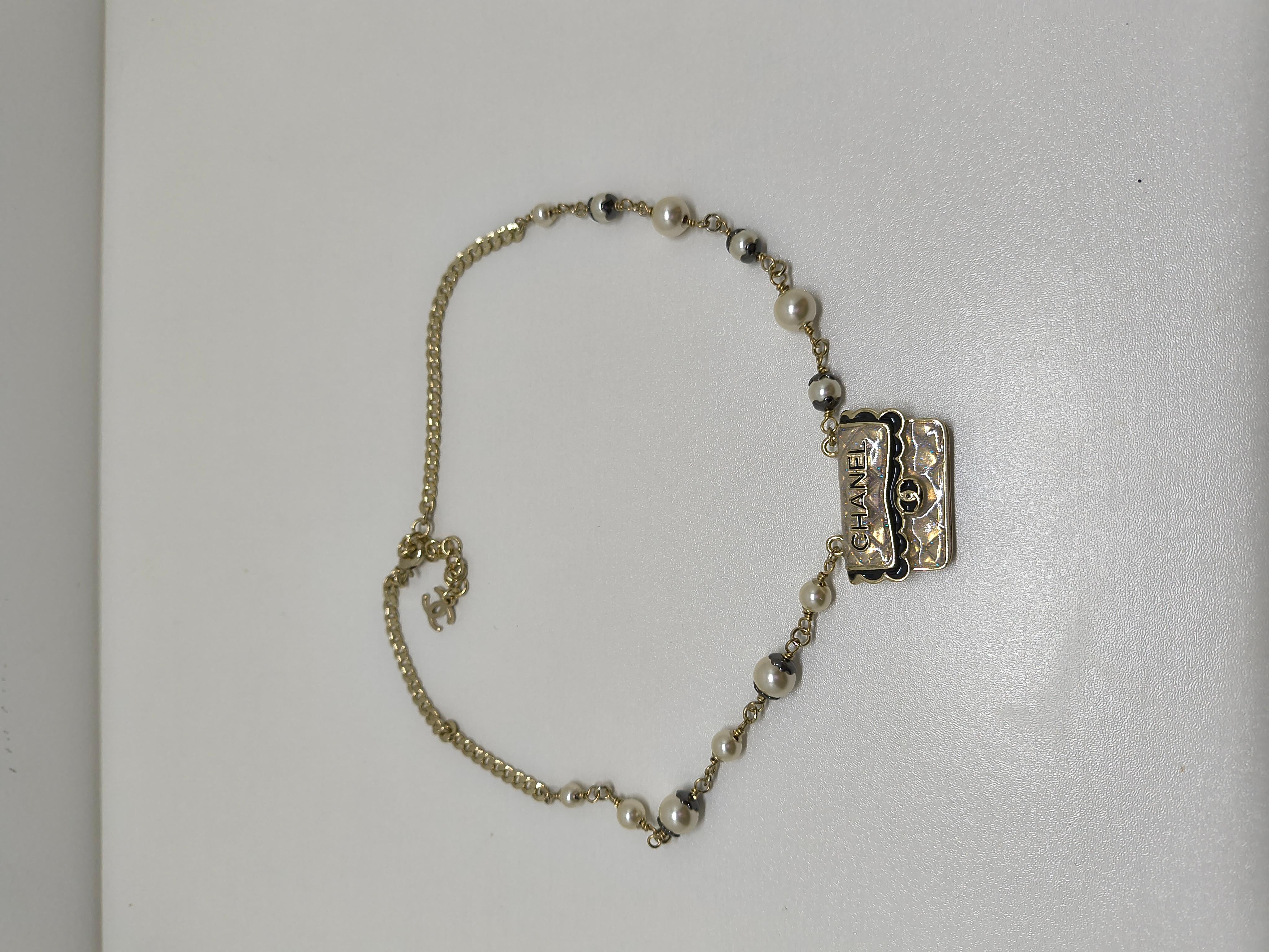 Elevate your jewelry collection with the exquisite Chanel CF Bag Pendant Pearl Choker—a statement piece that perfectly blends elegance and iconic Chanel design. This stunning choker features a delicate strand of lustrous pearls, gracefully draping