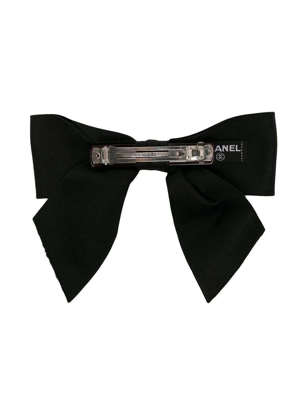 This timeless pre-owned 1980s bow clip from Chanel features a black silk ribbon bow with a barrette fixed on the back. This clip is simple yet very chic and can elevate any outfit for a fun yet sophisticated look. 

Colour: Black

Composition:
Trims