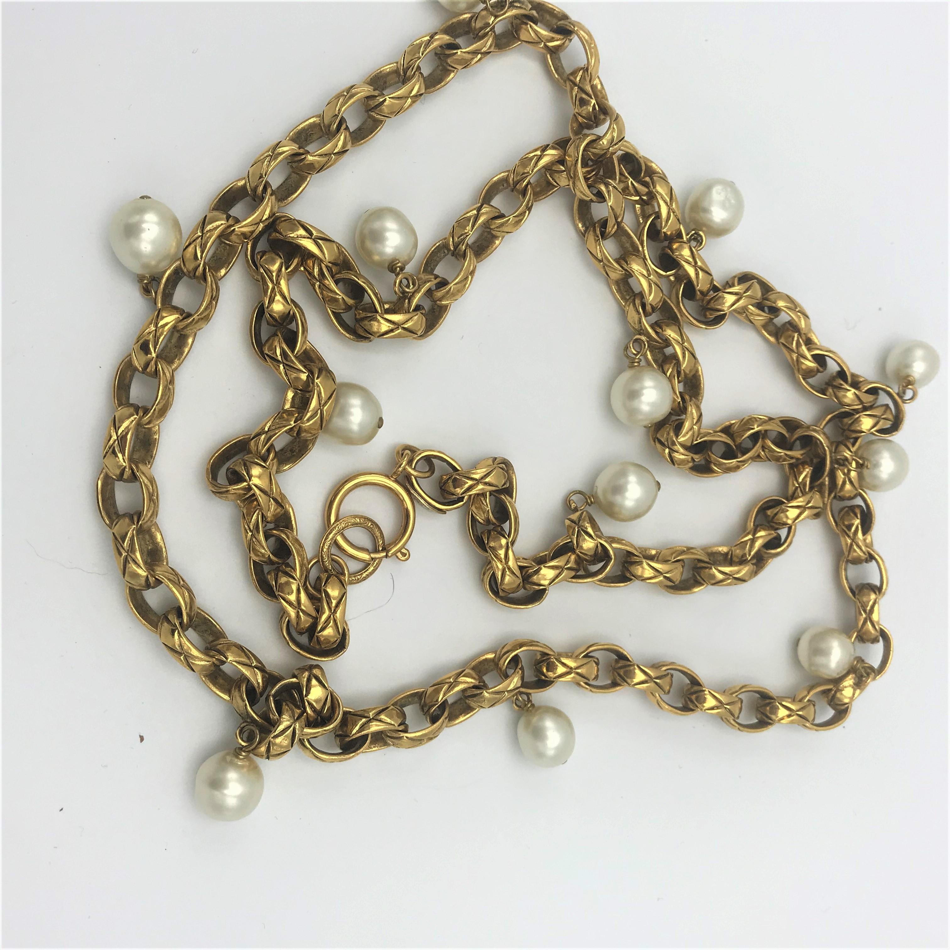 Timeless, typical CHANEL Necklace designed by Victoire de Castellane, signed 2CC3 = 1985, her 1st collection for CHANEL. Length of the necklace  150 cm with the typical watch clasp closer. There are 12 imitation pearls hanging on the quilted