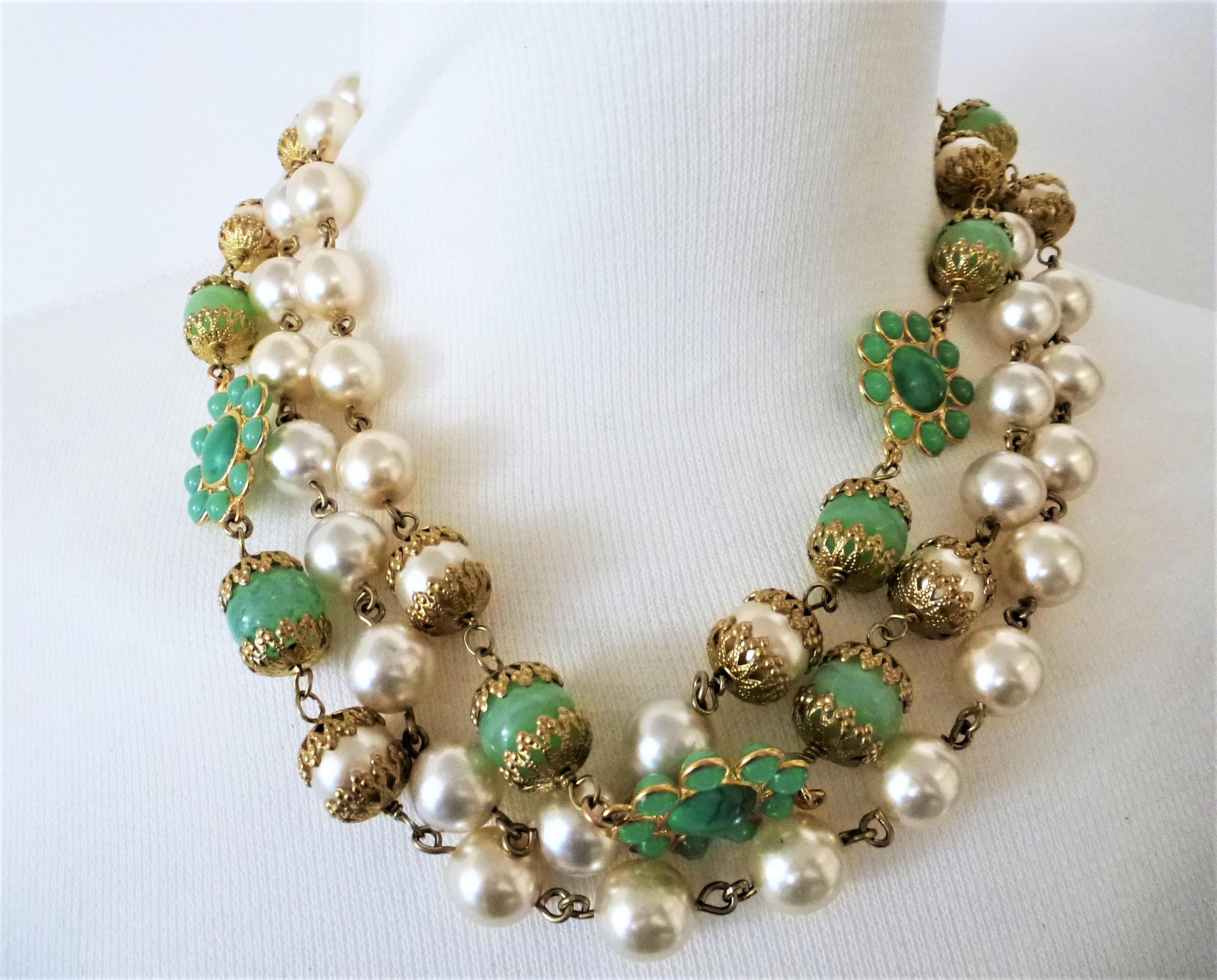 A fancy CHANEL Necklace/ Sautoir with false pearls and 5 jade colored rosettes, double-sided and flanked by a jade ball and a pearl they are gold decorated! Very good work !
The length of the necklace is 150/75 cm long and without a lock. Rosette