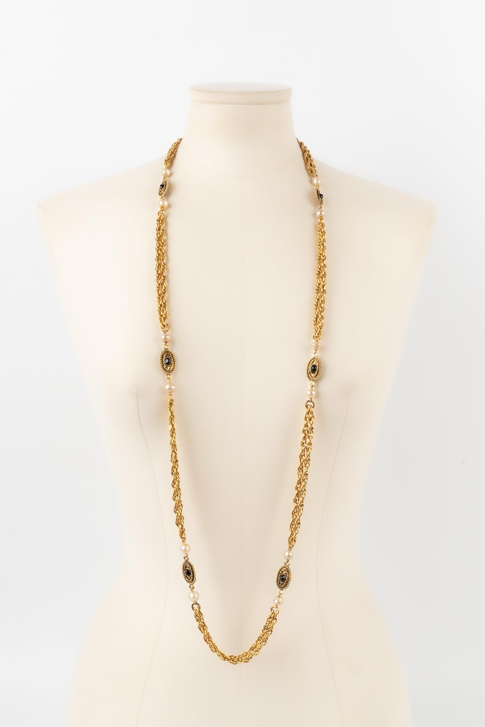 Chanel - (Made in France) Golden metal necklace/sautoir with costume pearls and tiny glass paste cabochons. 1982 Collection.

Additional information:
Condition: Very good condition
Dimensions: Length: 111 cm

Seller Reference: CB212