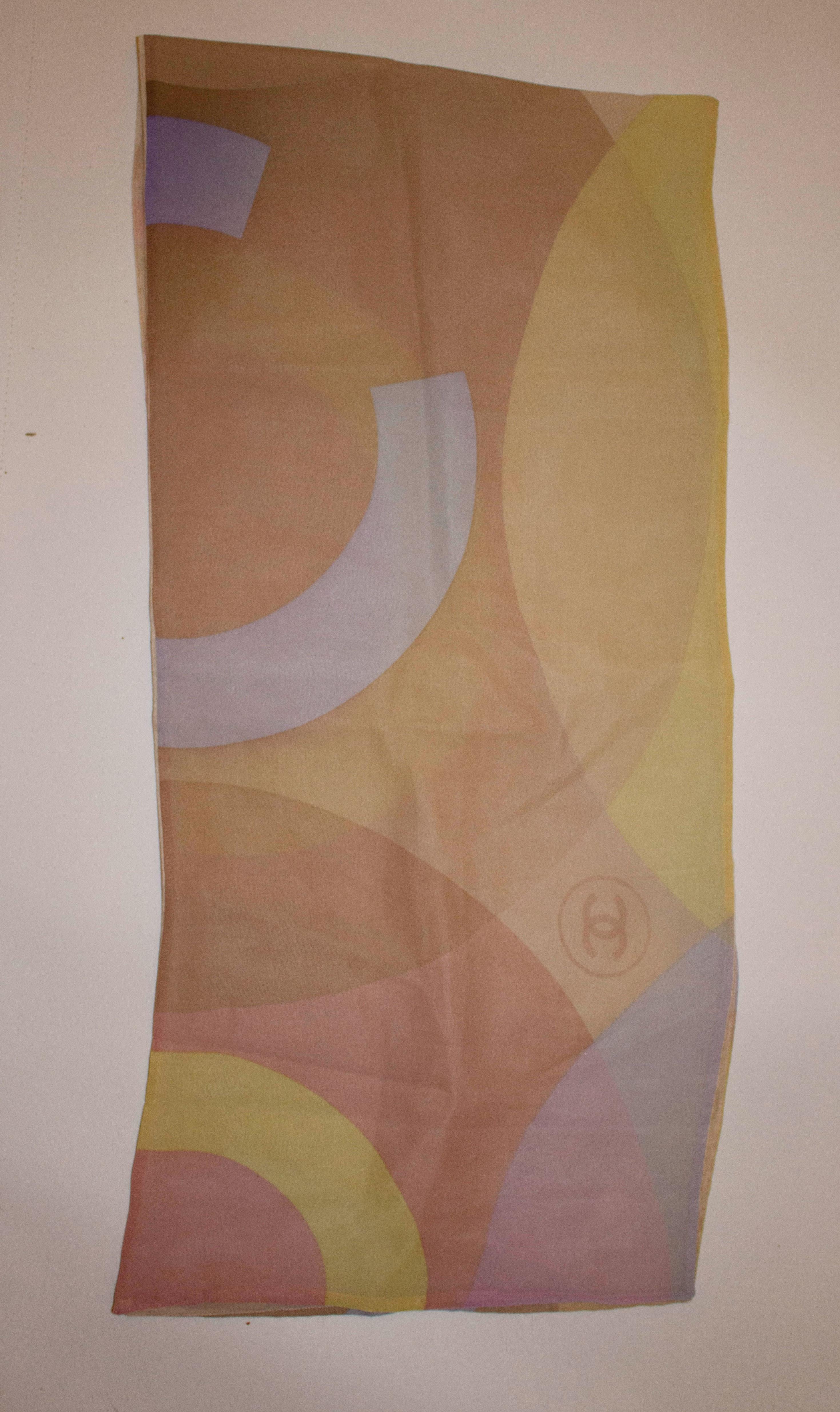 A pretty Chanel silk scarf  for Spring / Summer in a mix of colours, pink, yellow ,caramel and blue . The scarf  has the Chanel logo incorporated into the fabric. 
Measurements: length 54''  width 12 1/2''