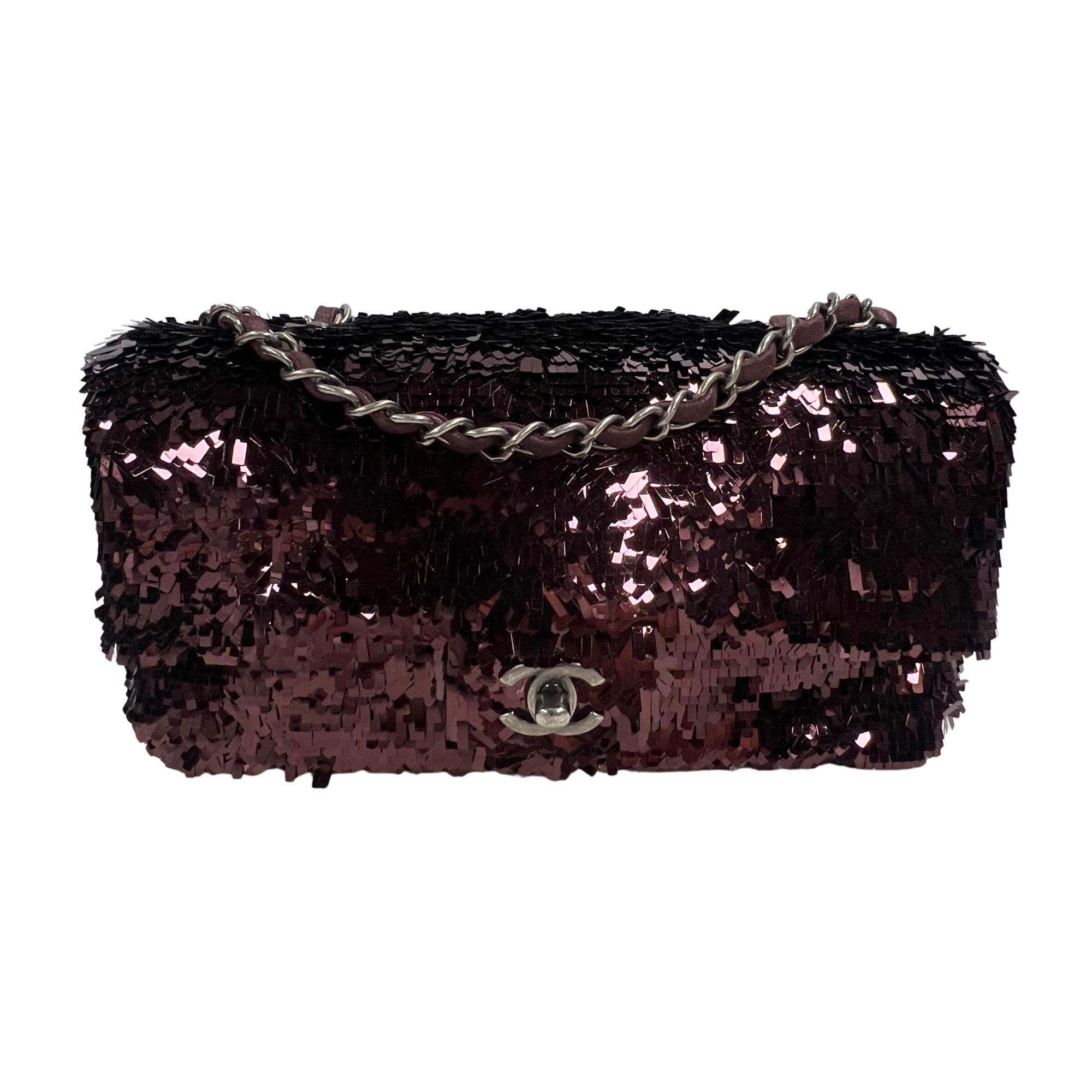Chanel sequinned Timeless flap bag in dark burgundy form 2014. The bag features an exterior of long sequins throughout, ruthenium metal hard, a long chain and leather shoulder strap, a front flap with CC turn lock closure and is finished with a