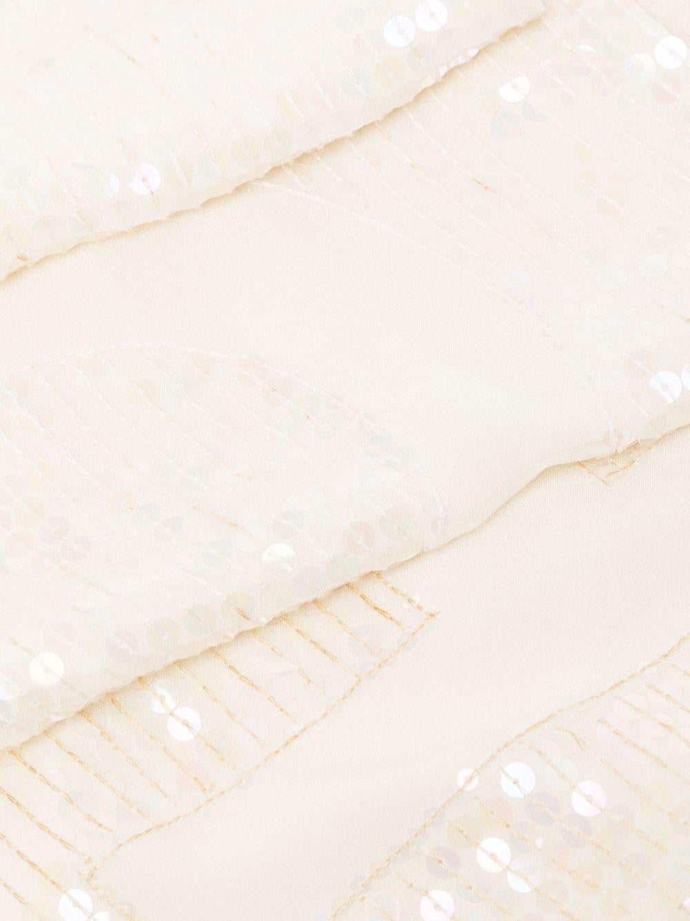 This chic pre-owned Chanel sequin scarf was crafted in France and is composed of the purest silk. Embellished with sequins in the Chanel Maison's classic CC interlocking logo, this pearl white scarf is the perfect neutral tone to style with any